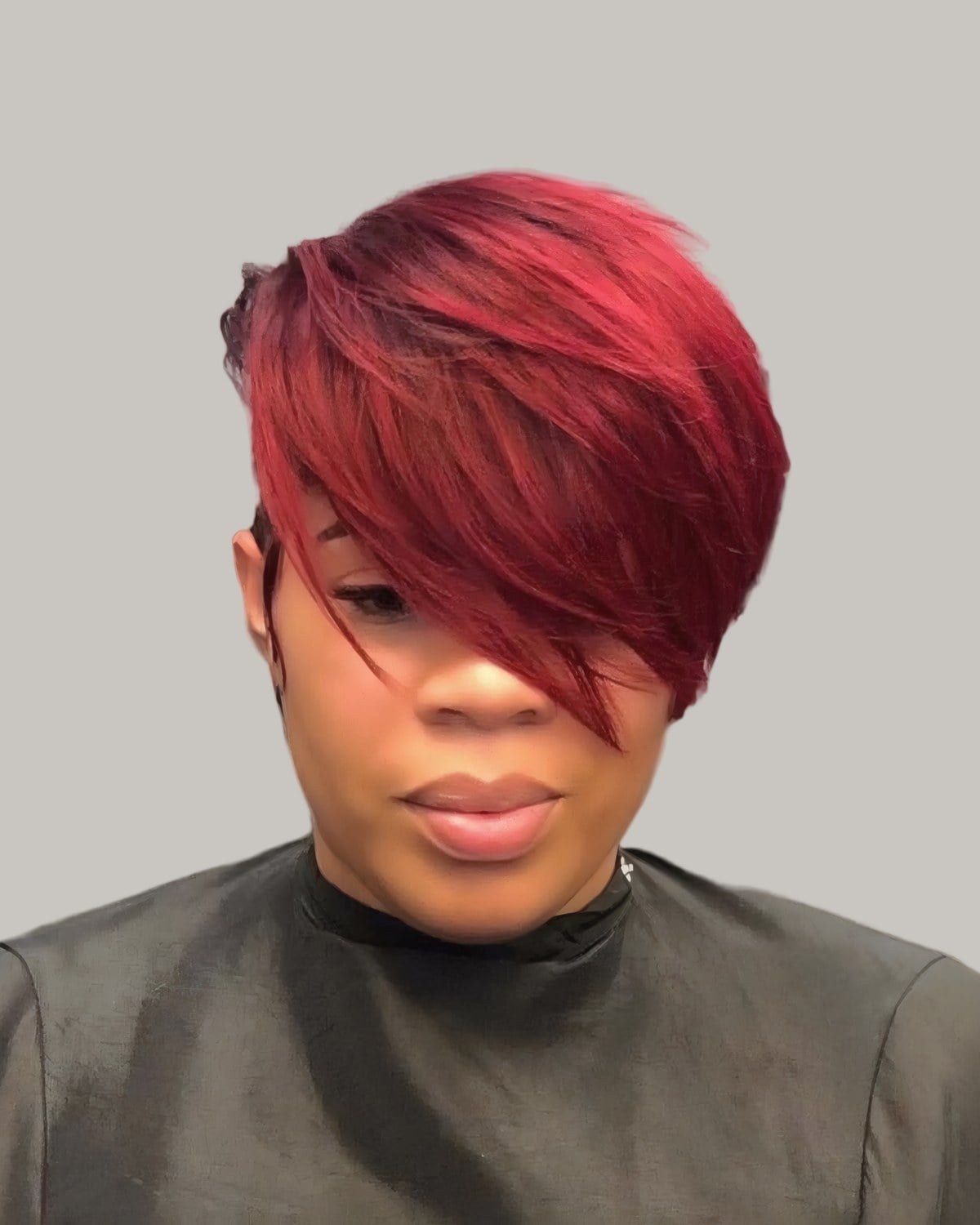 Woman with a bright red pixie, the fringe covering one eye