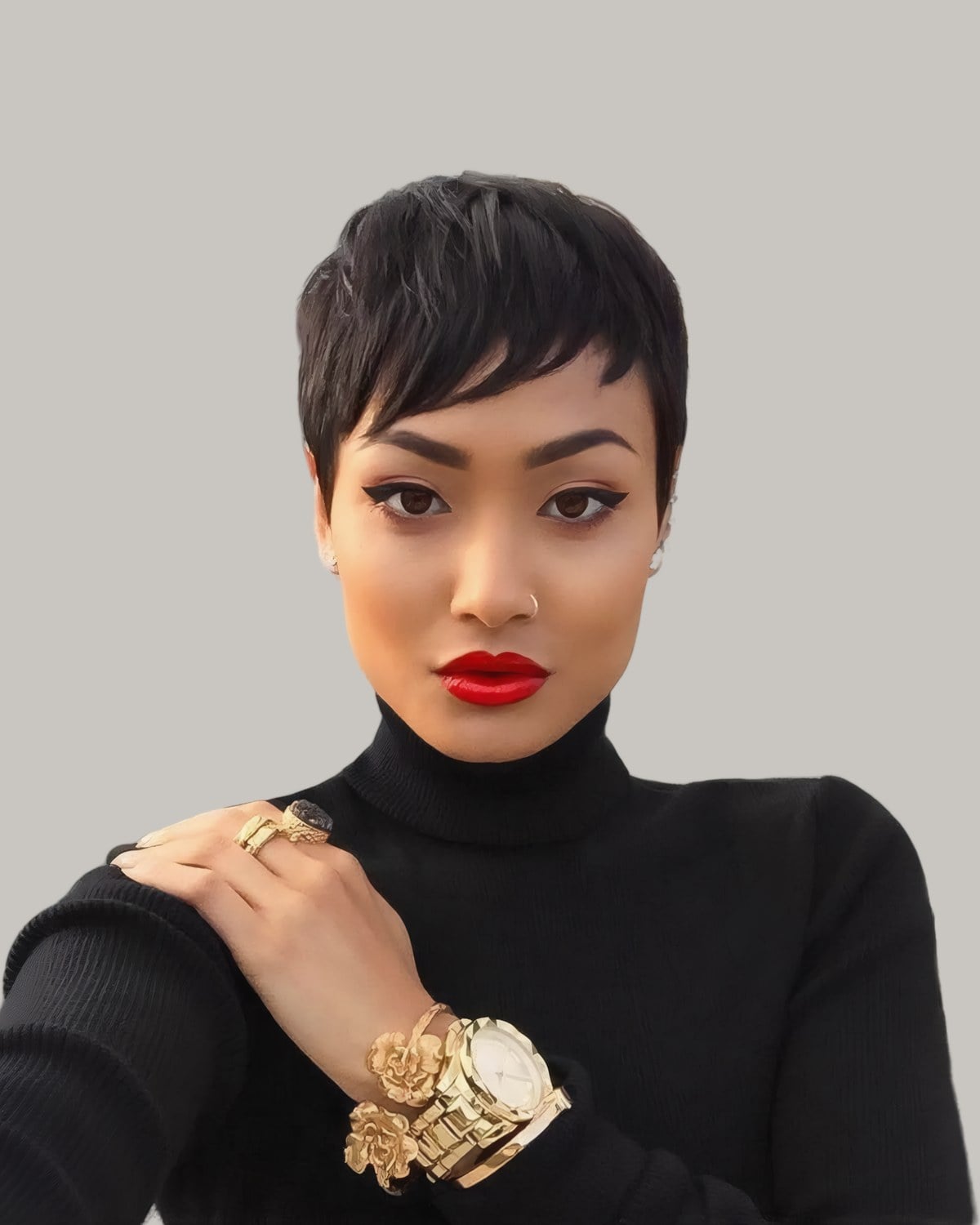 Woman with a short black pixie and red lipstick, hands crossed at her chest