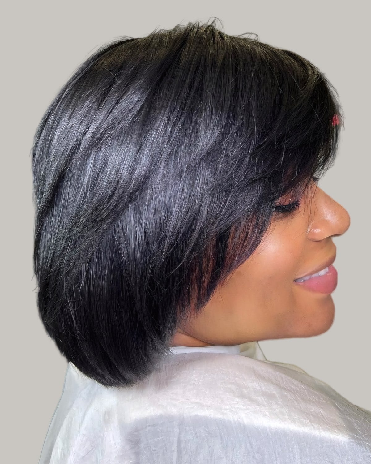 Woman with a black layered bob, looking down to one side
