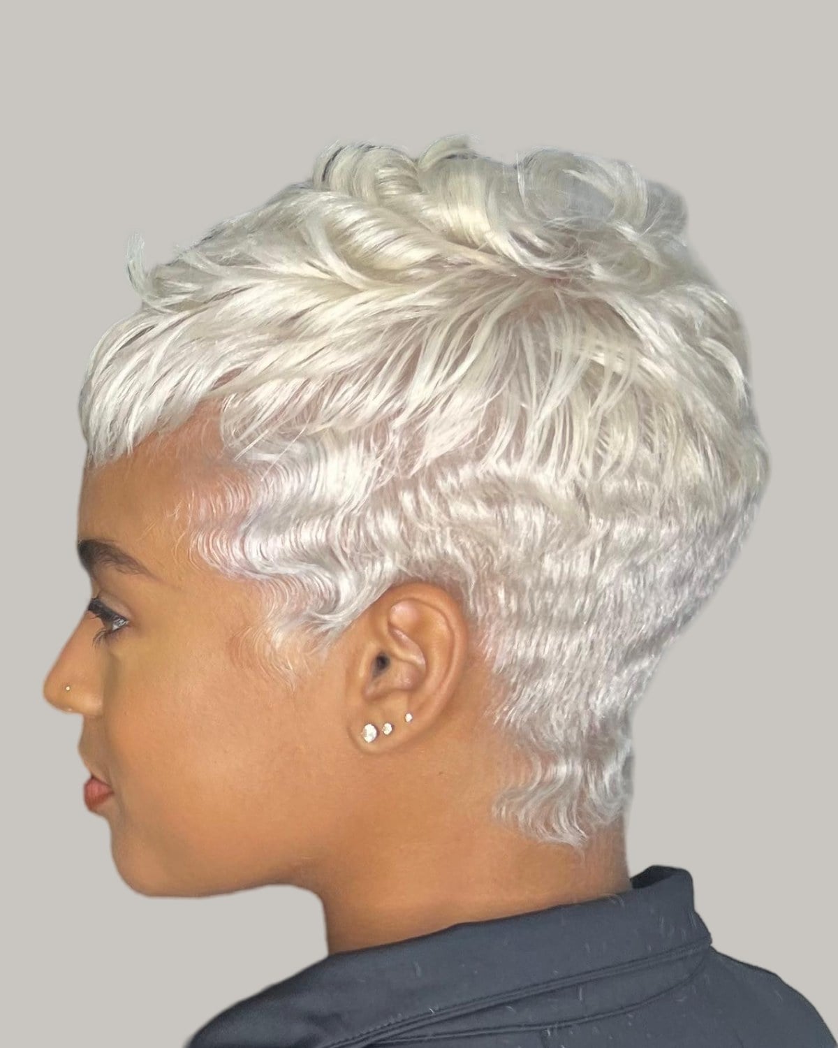Woman with a silvery platinum pixie seen from the side