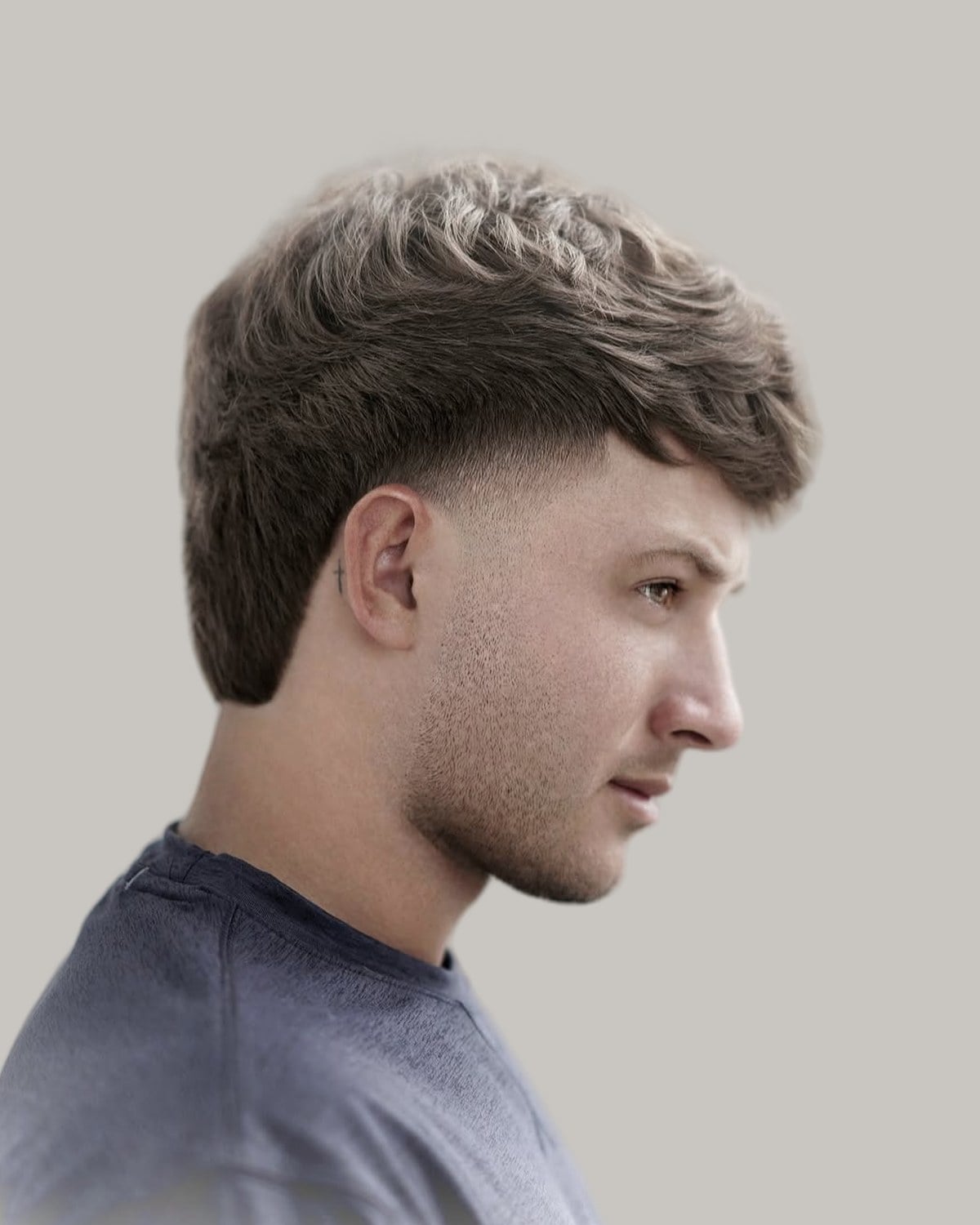 Man with a light brown textured fringe and a burst taper, seen in profile