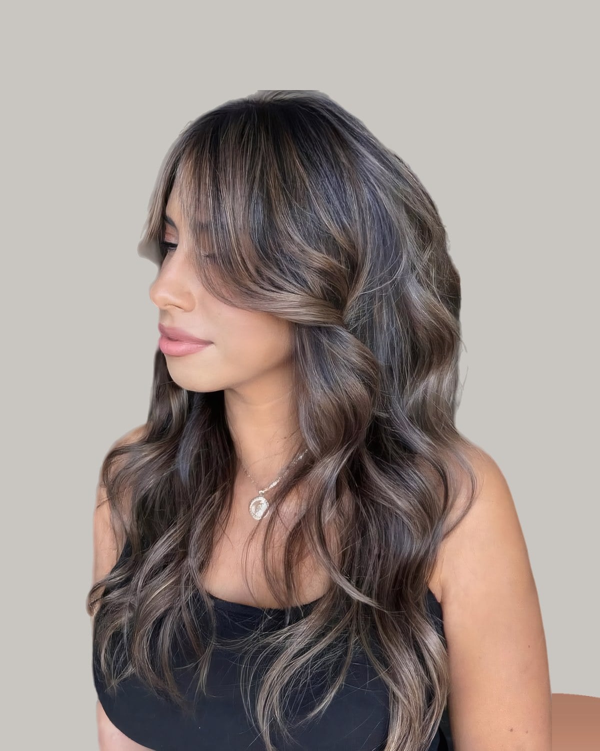 Woman in profile with long brunette waves and fine lighter strands