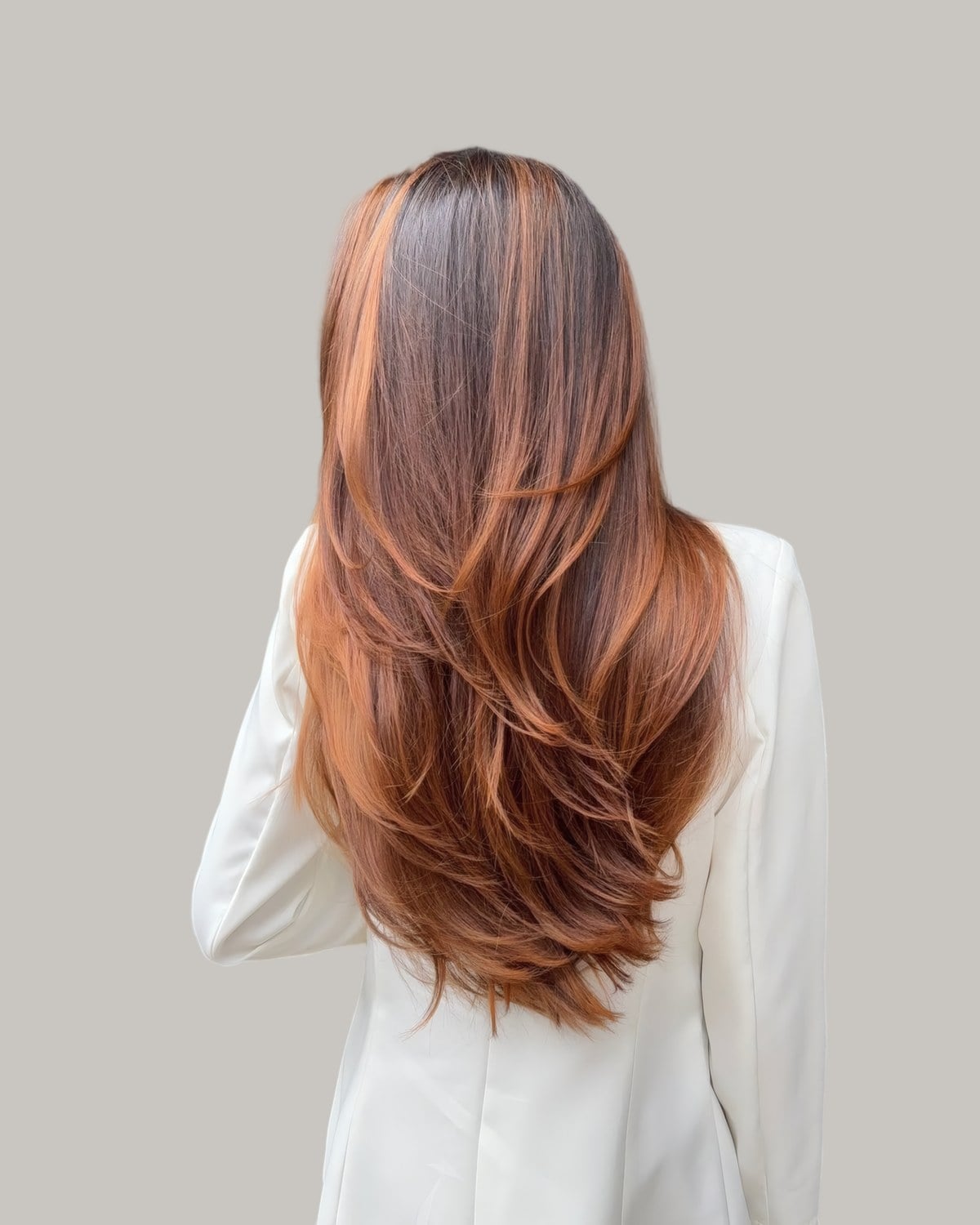 Back view of long copper-brown hair in a white blazer, cut in long layers