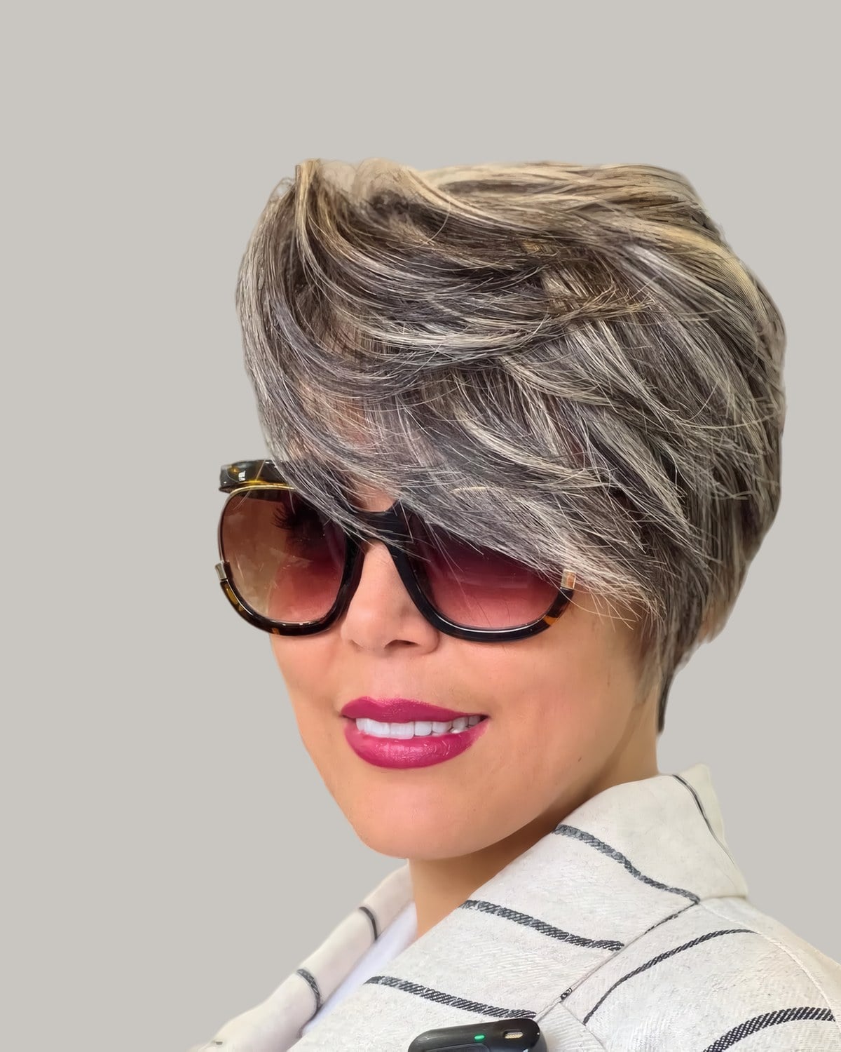 Woman in large sunglasses with a short, silvery-blonde pixie swept high over one side