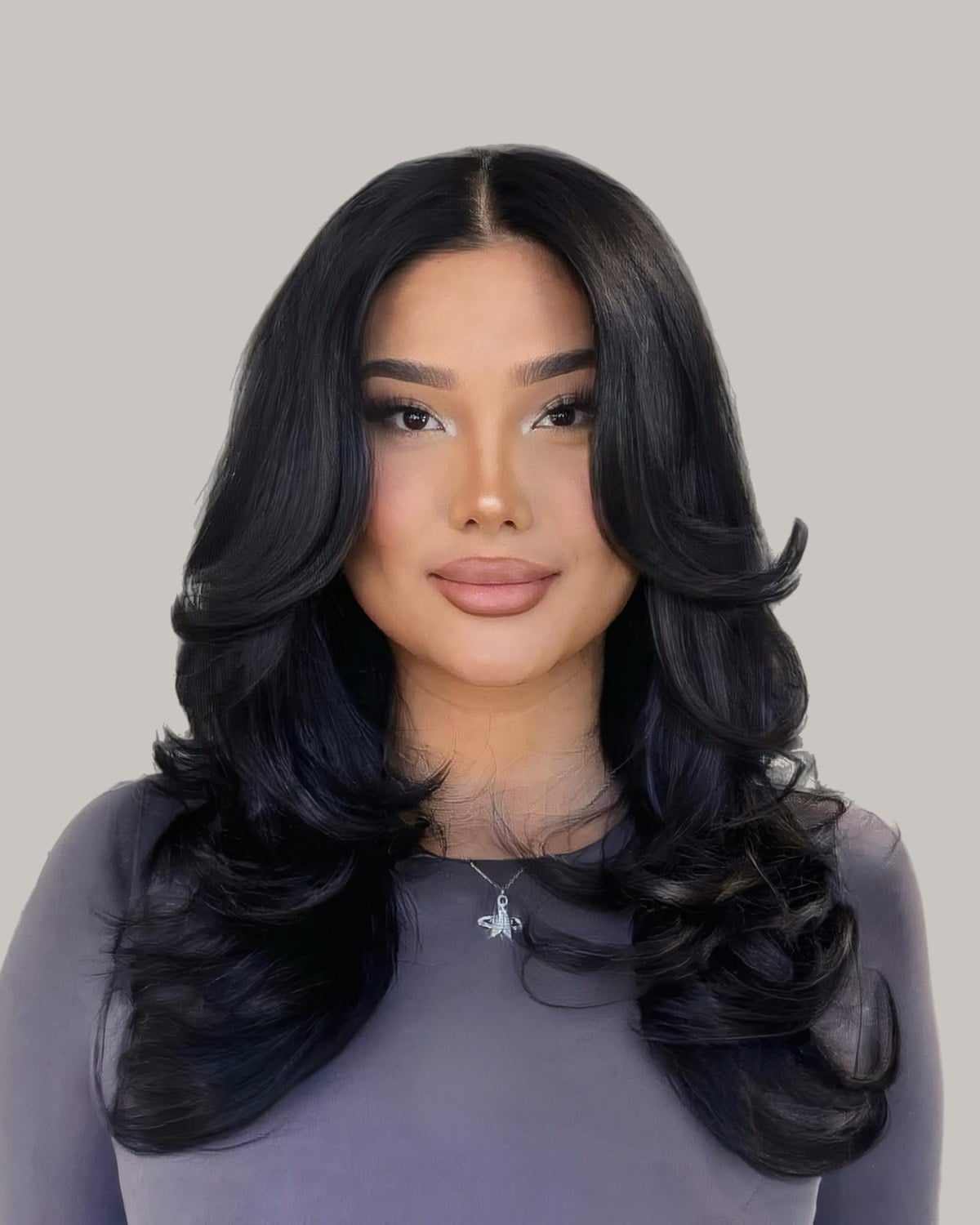 Woman with long black hair blow-dried into big, glossy face-framing curls