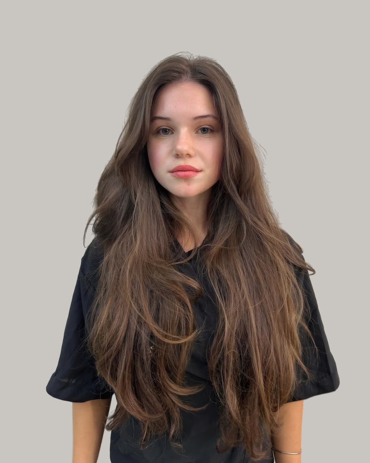 Woman in a black T-shirt with very long brown hair in soft layers