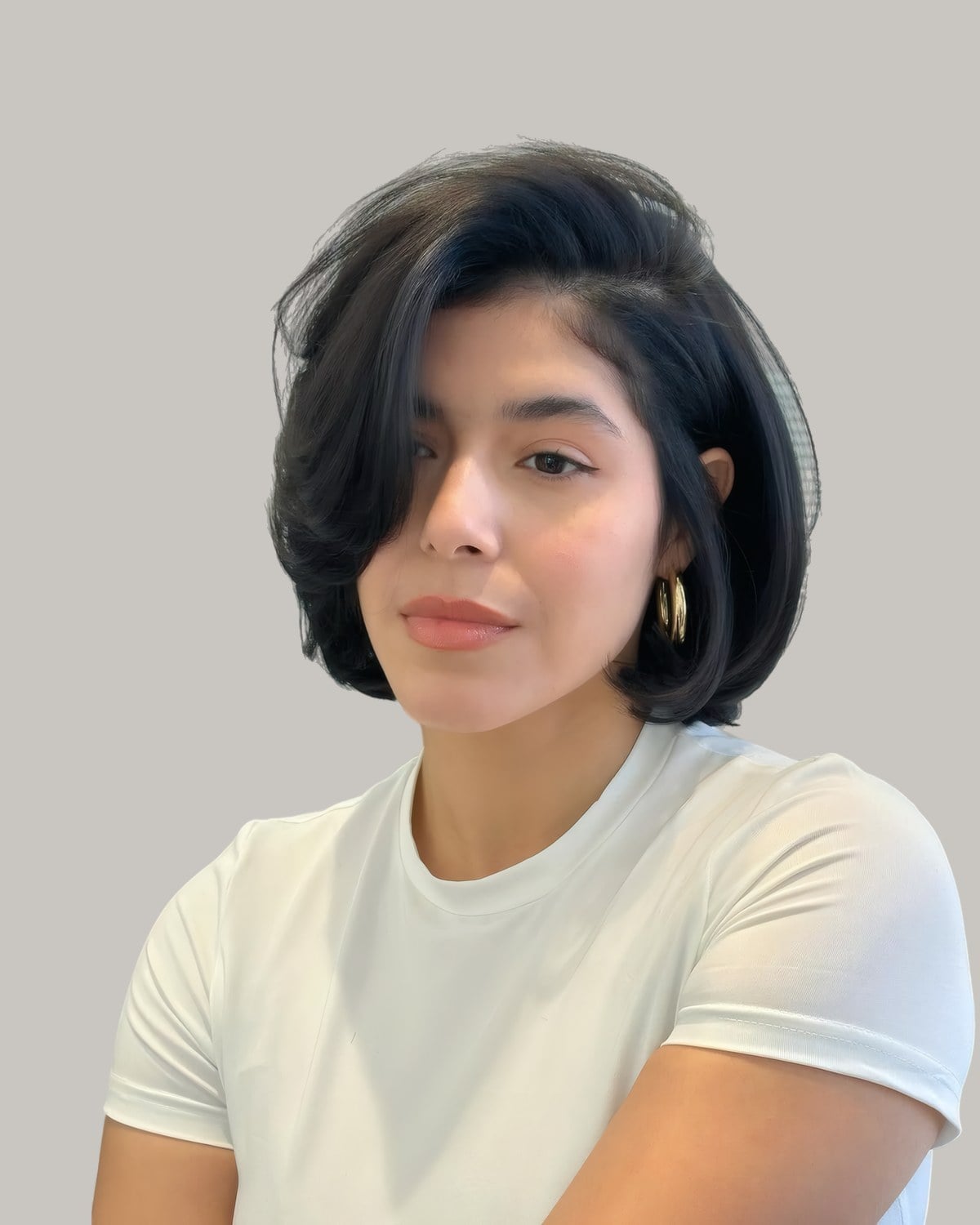 Woman in a white T-shirt with a glossy black bob swept to one side