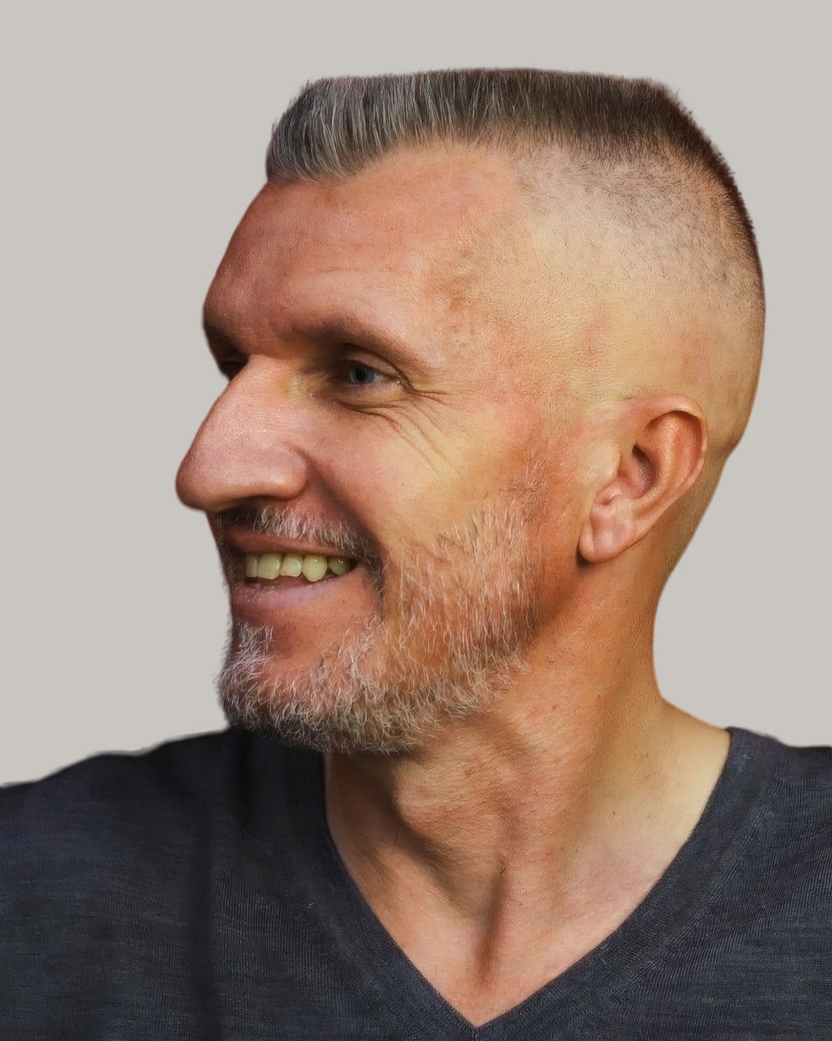 Older man with a grey buzz cut and a high fade, looking to the side