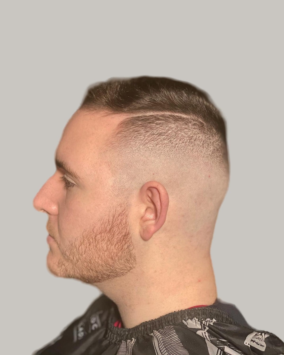 Man with a buzz cut and a high skin fade, seen in profile