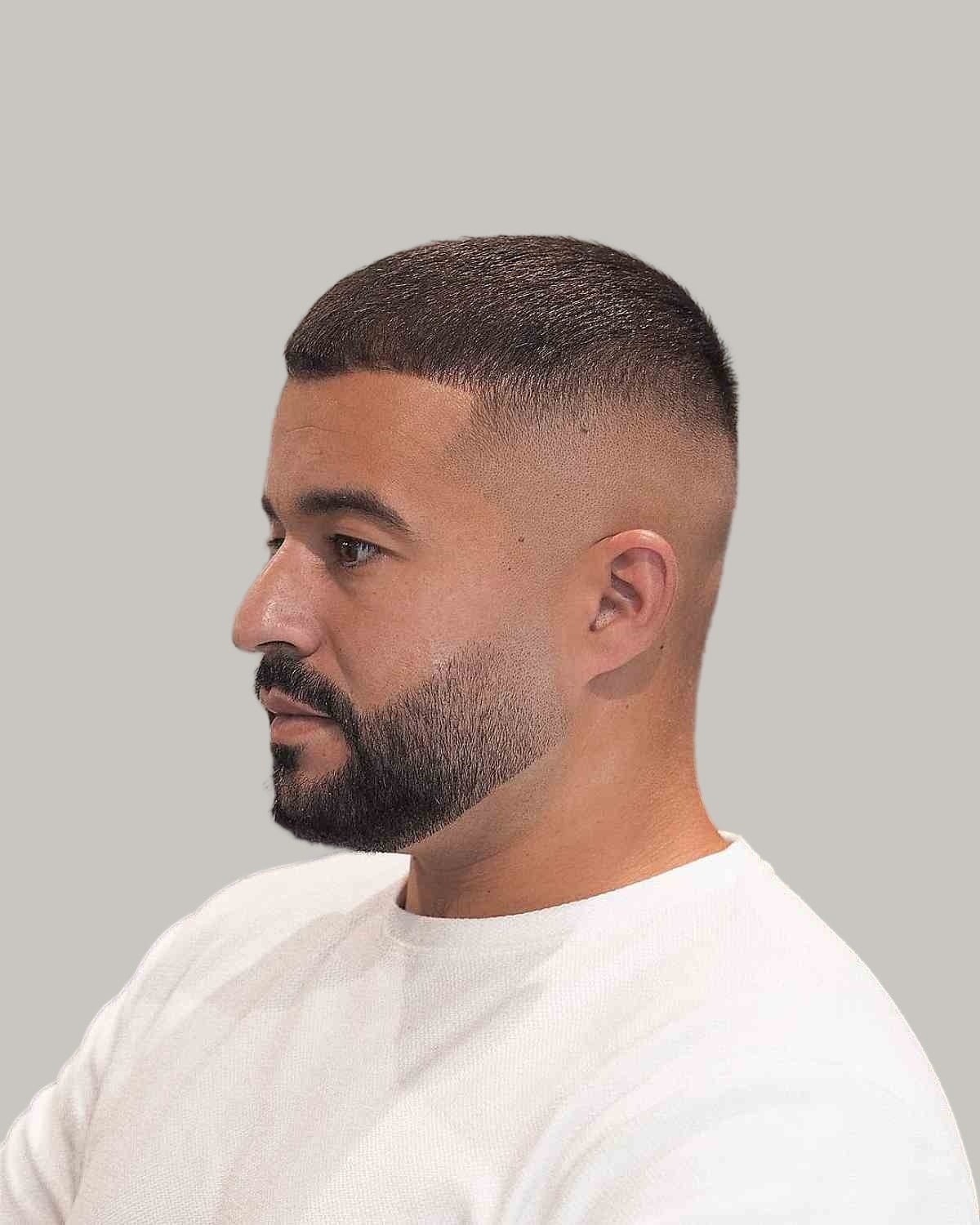 Man with a buzz cut, a low skin fade and a short beard, seen in profile
