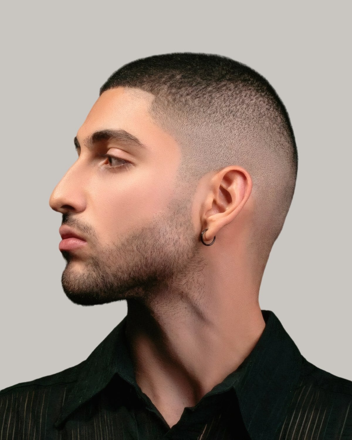 Man with a number 3 buzz cut and stubble, seen in profile