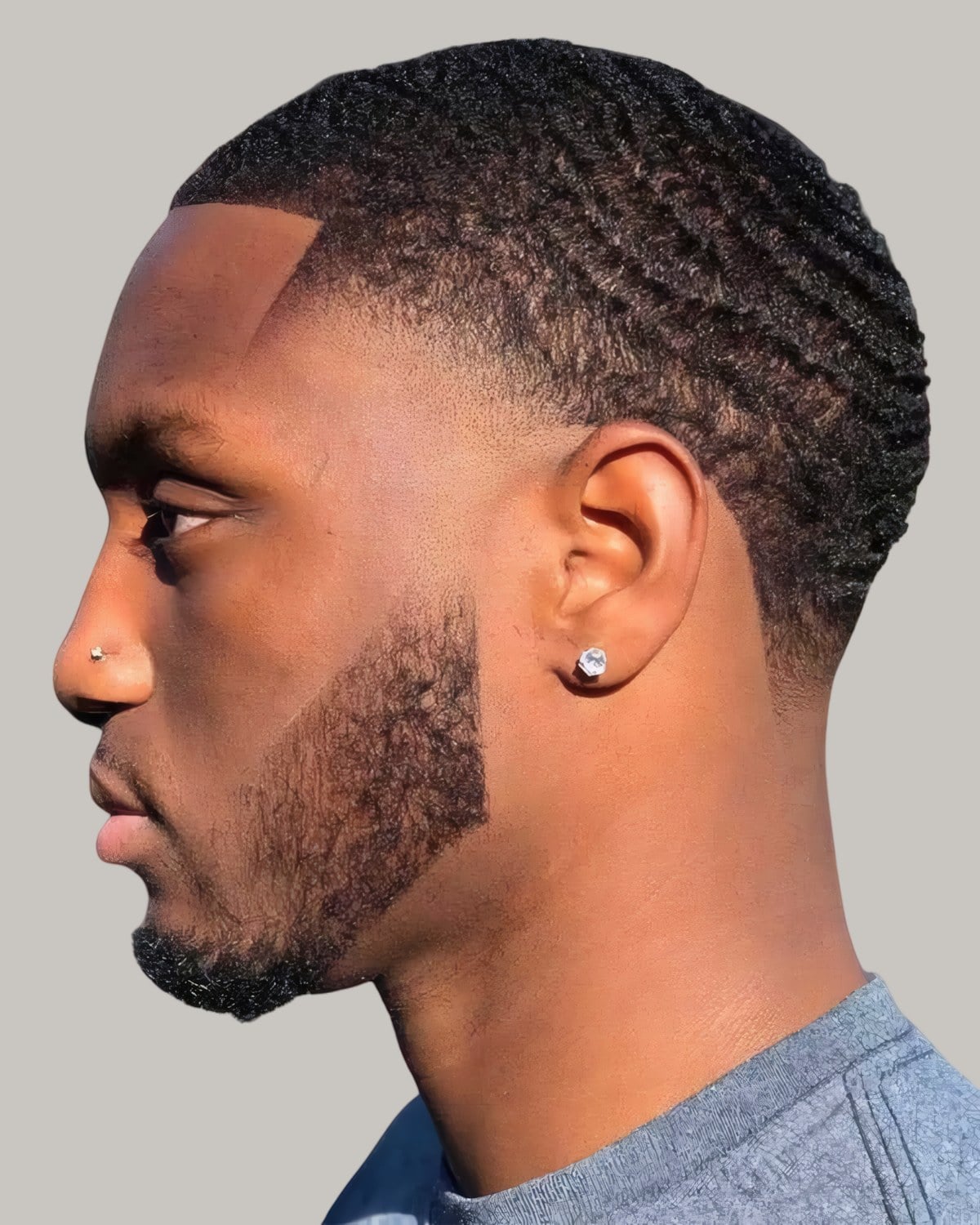 Black man with a buzz cut and a temple fade, seen in profile