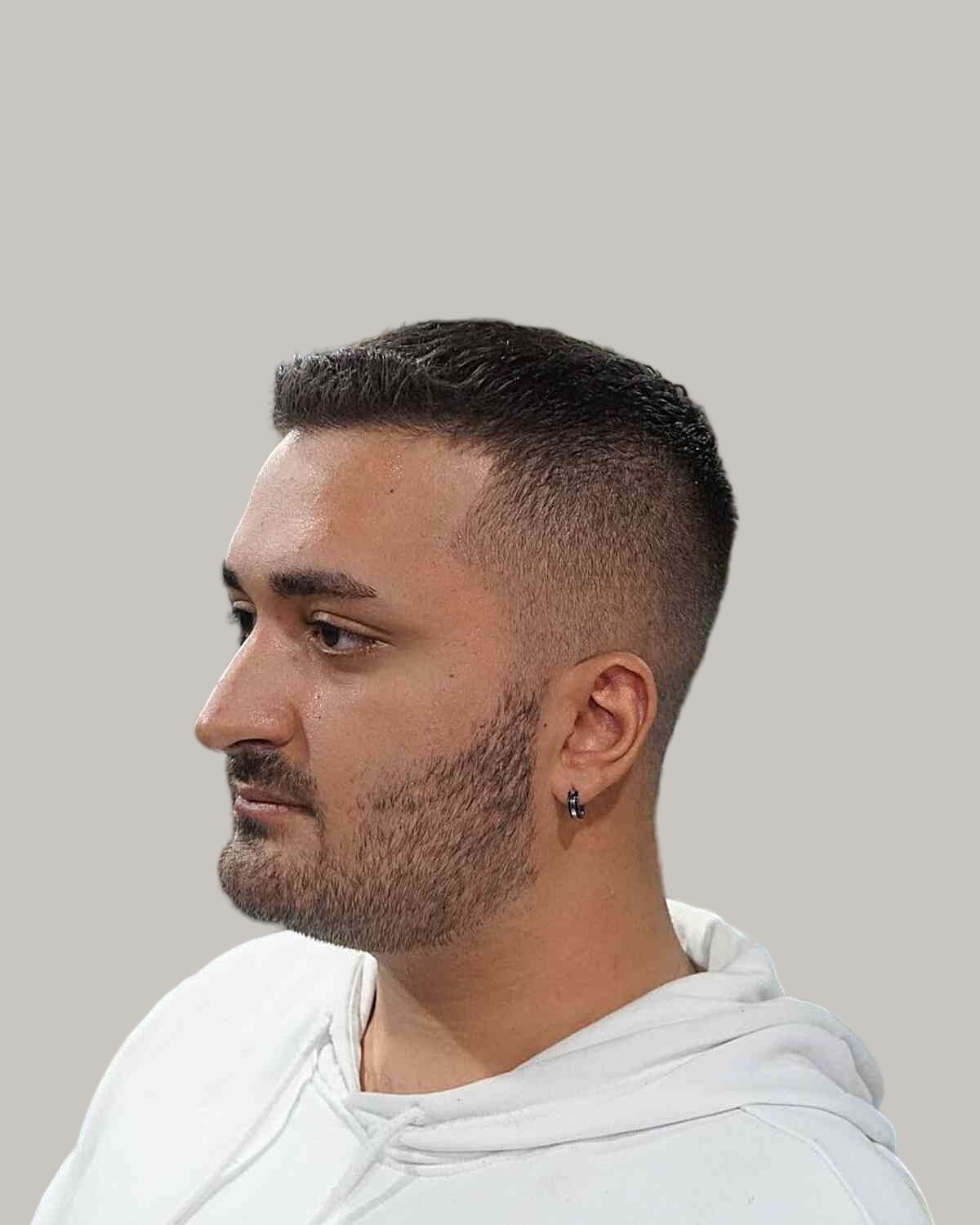 Man with a short buzz cut and a low skin fade on thinning hair, seen in profile