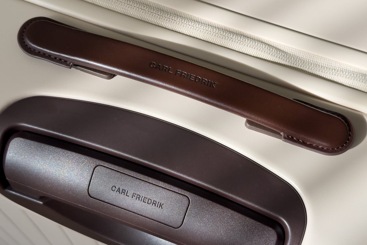 Carl Friedrik leather carry handle above the branded trolley handle - Luxe Digital