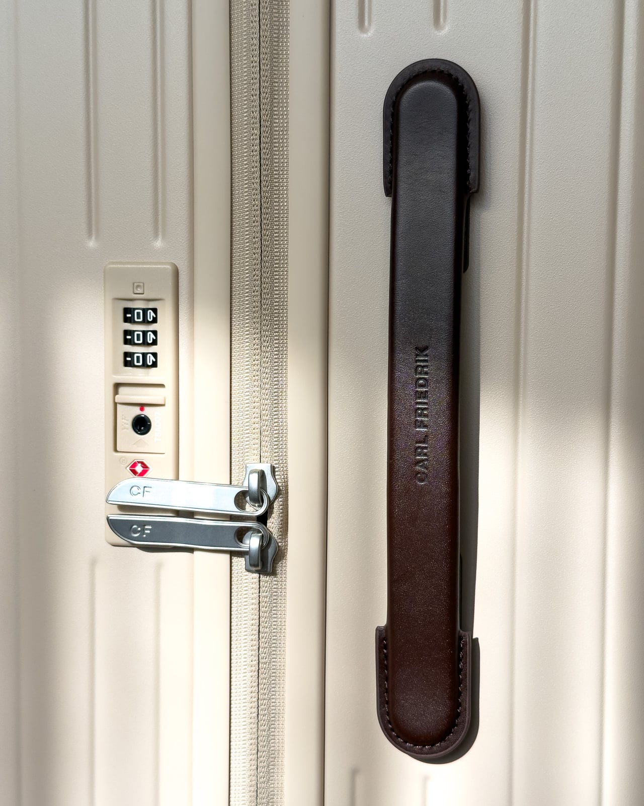 TSA-approved combination lock and leather side handle on the Carl Friedrik suitcase - Luxe Digital