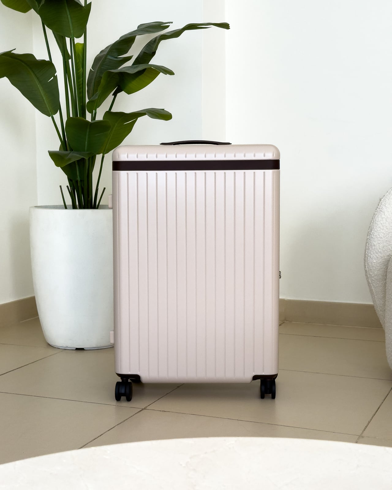 Carl Friedrik Core Check-In Large in Sand/Chocolate standing in a bright room - Luxe Digital