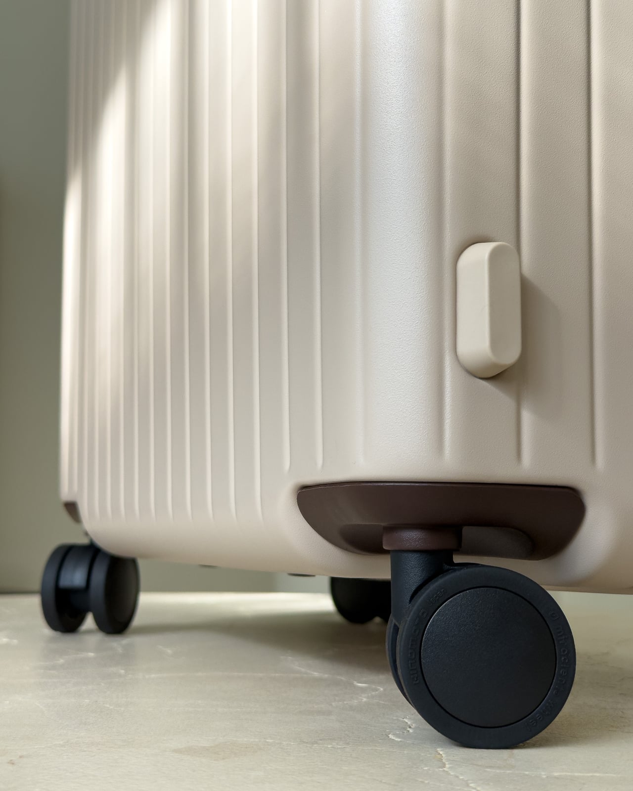 Close-up of a Hinomoto spinner wheel under the Carl Friedrik suitcase - Luxe Digital