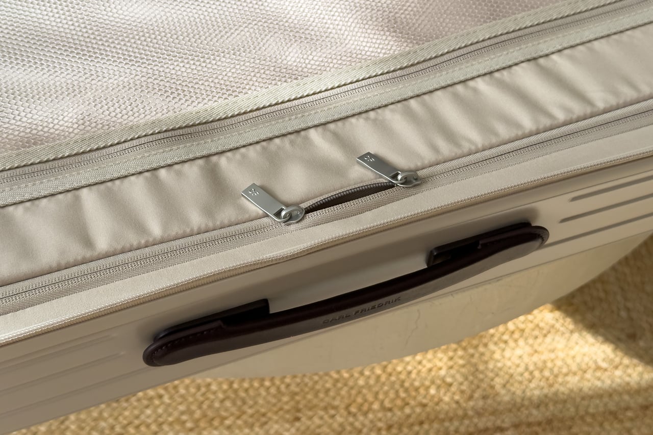 CF zip pull on a slim zippered pocket inside the Carl Friedrik suitcase - Luxe Digital