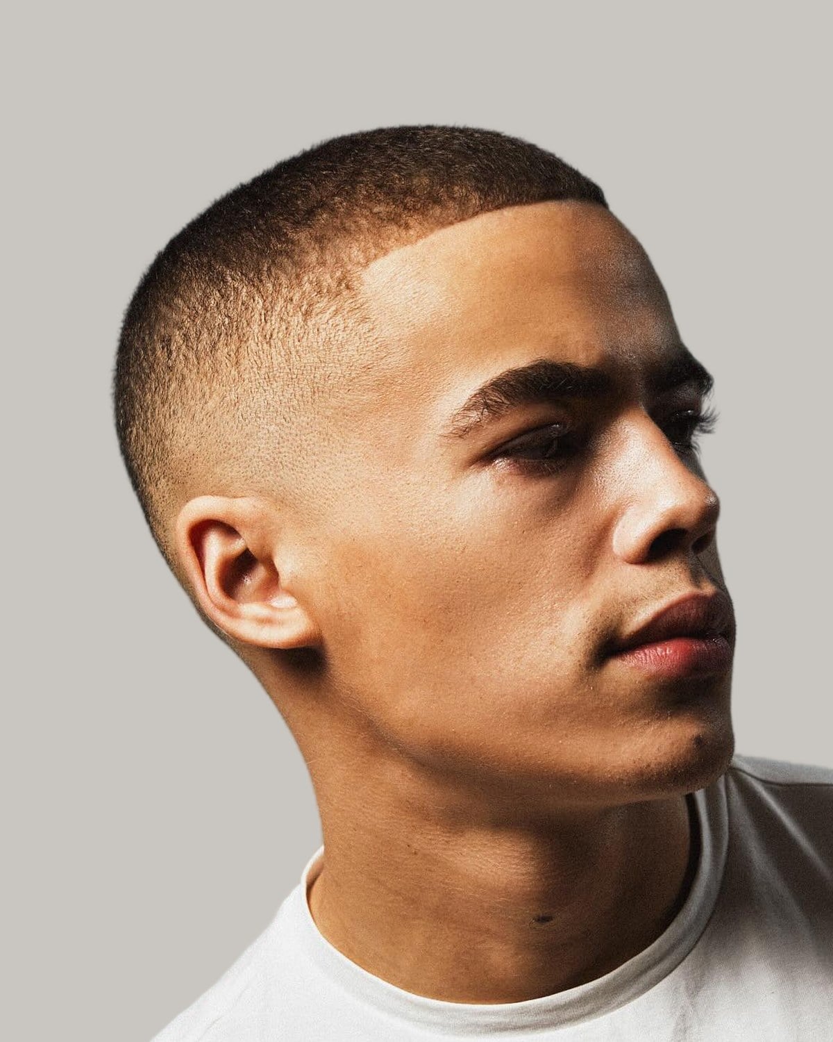 Man with a very short crew cut on Afro-textured hair, seen at an angle