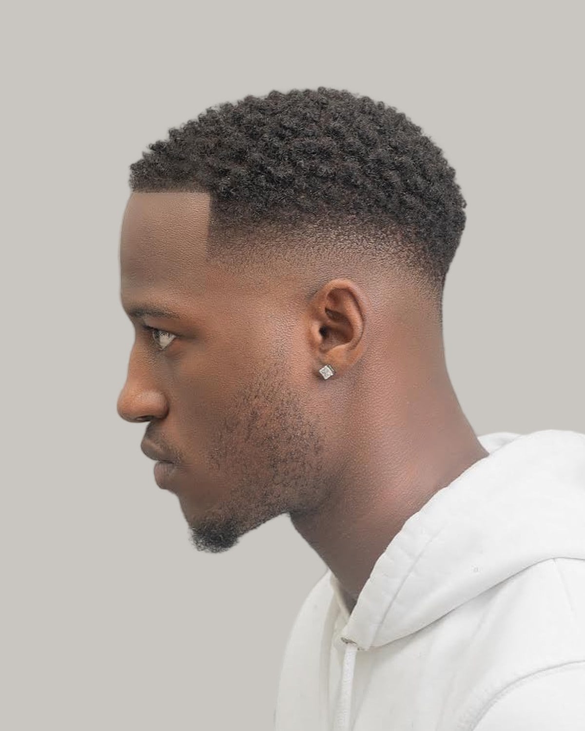 Man with a short crew cut on Afro-textured hair, seen in profile