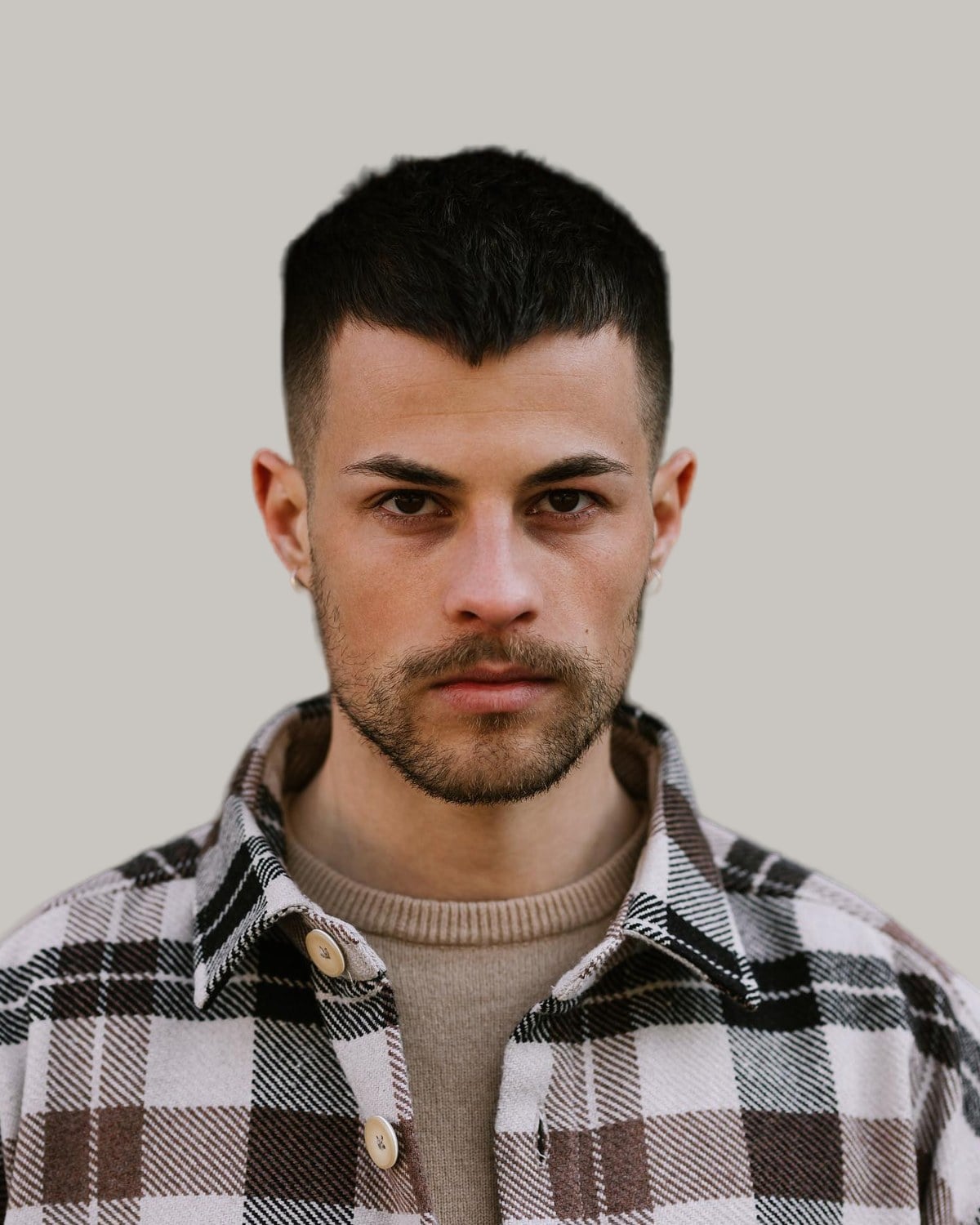 Man with a short dark crew cut and a trimmed beard, seen from the front