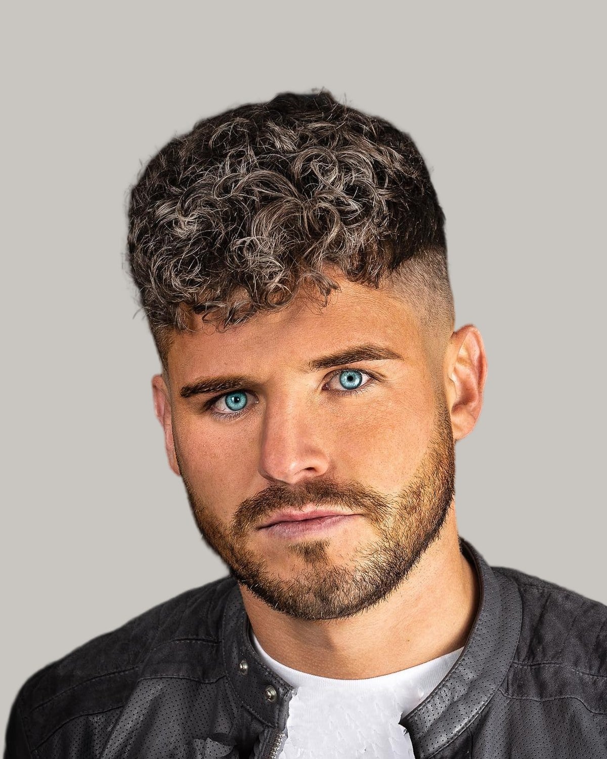 Bearded man with a curly crew cut and a fade, seen from the front