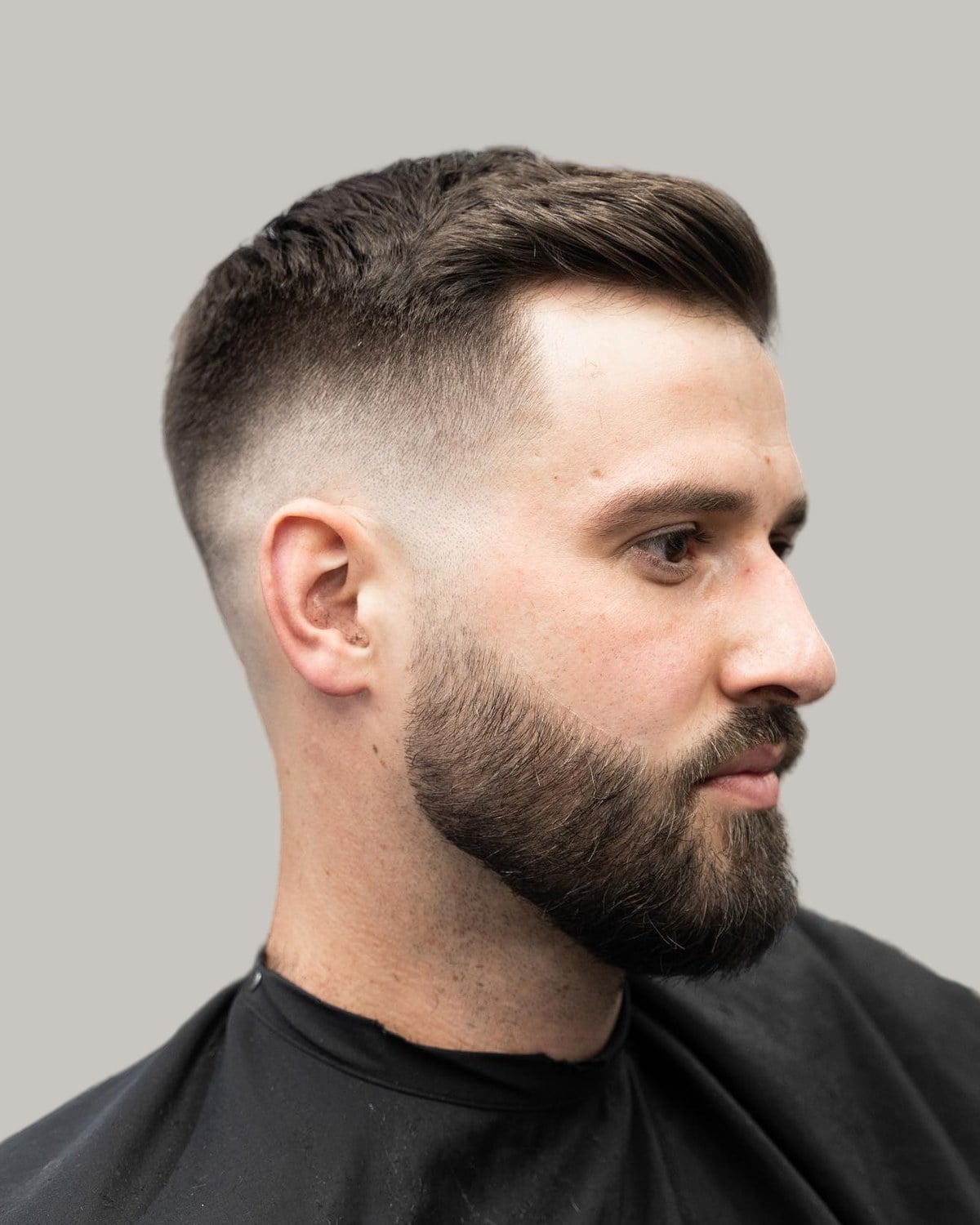 Man with a short crew cut and a full beard, seen at an angle