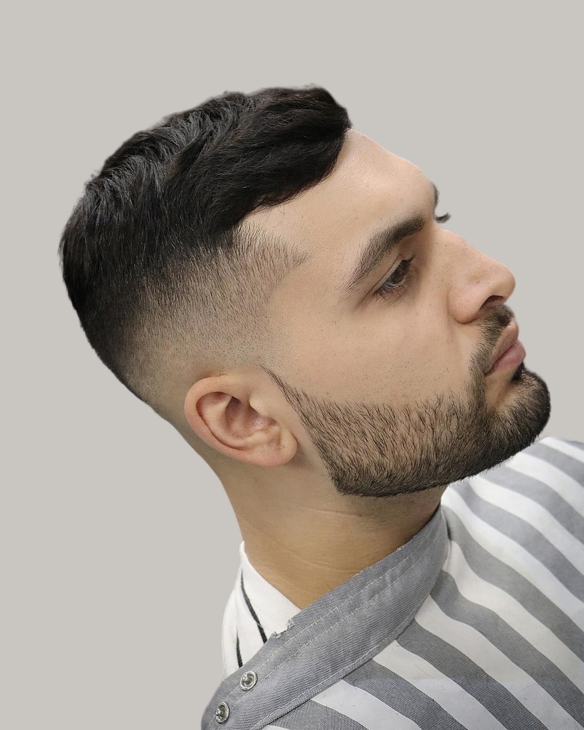 Bearded man with a crew cut and a hard part, seen in profile