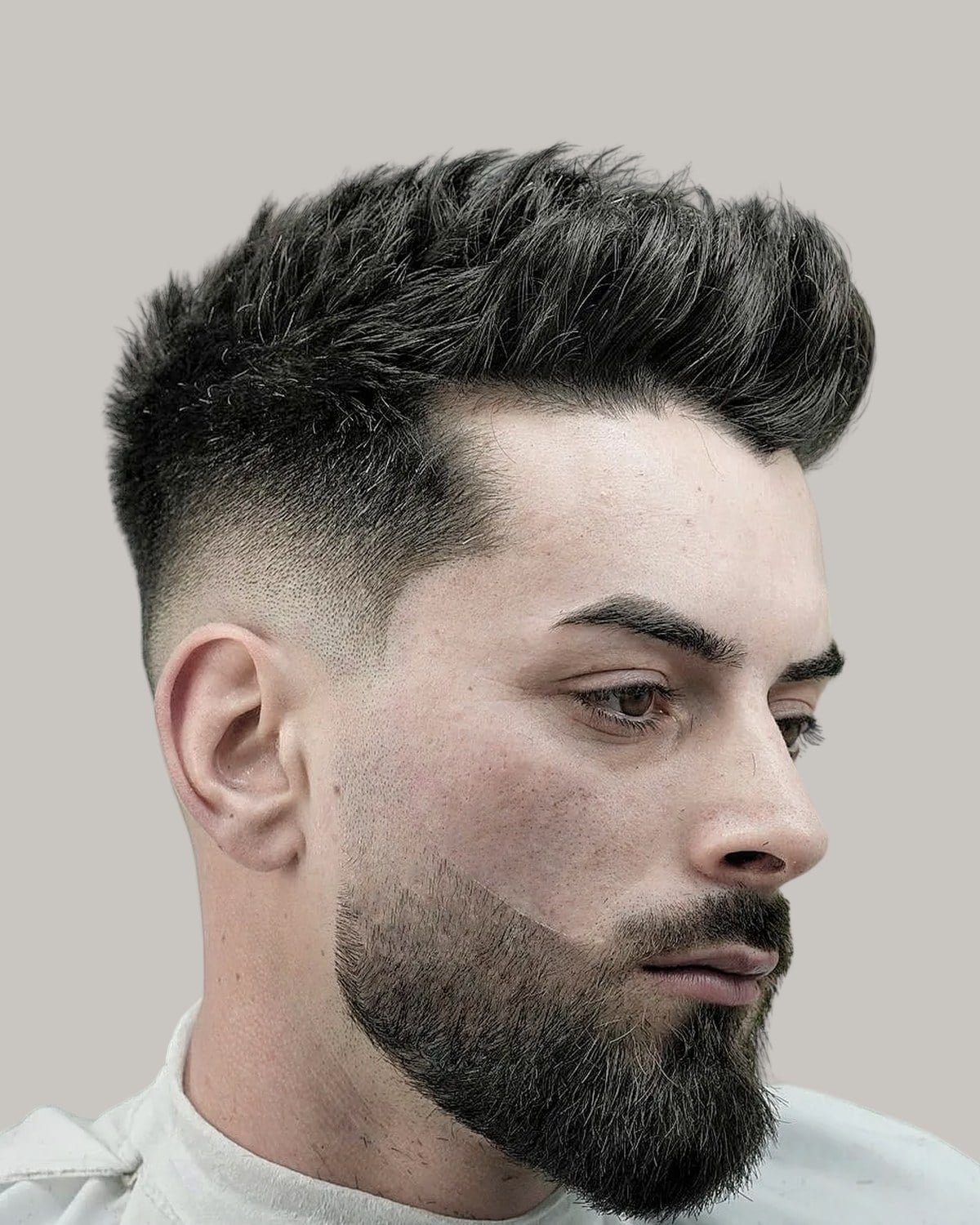 Bearded man with a long crew cut and a skin fade, seen at an angle