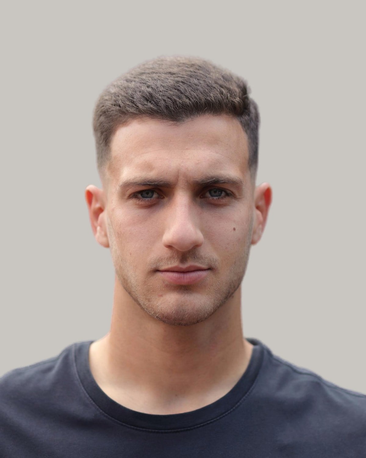 Man with a short dark crew cut, seen from the front