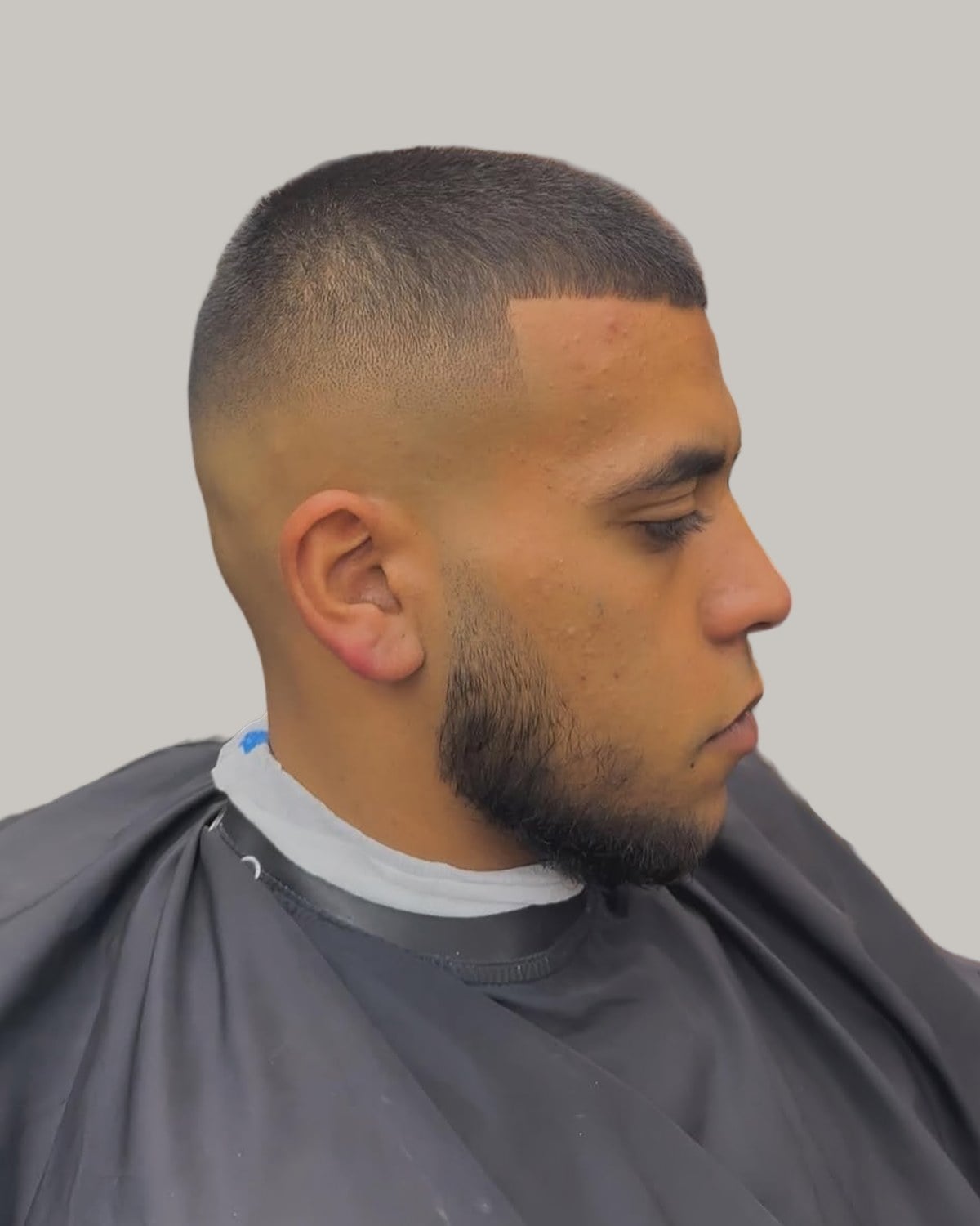 Bearded man with a short crew cut and a low skin fade, seen in profile