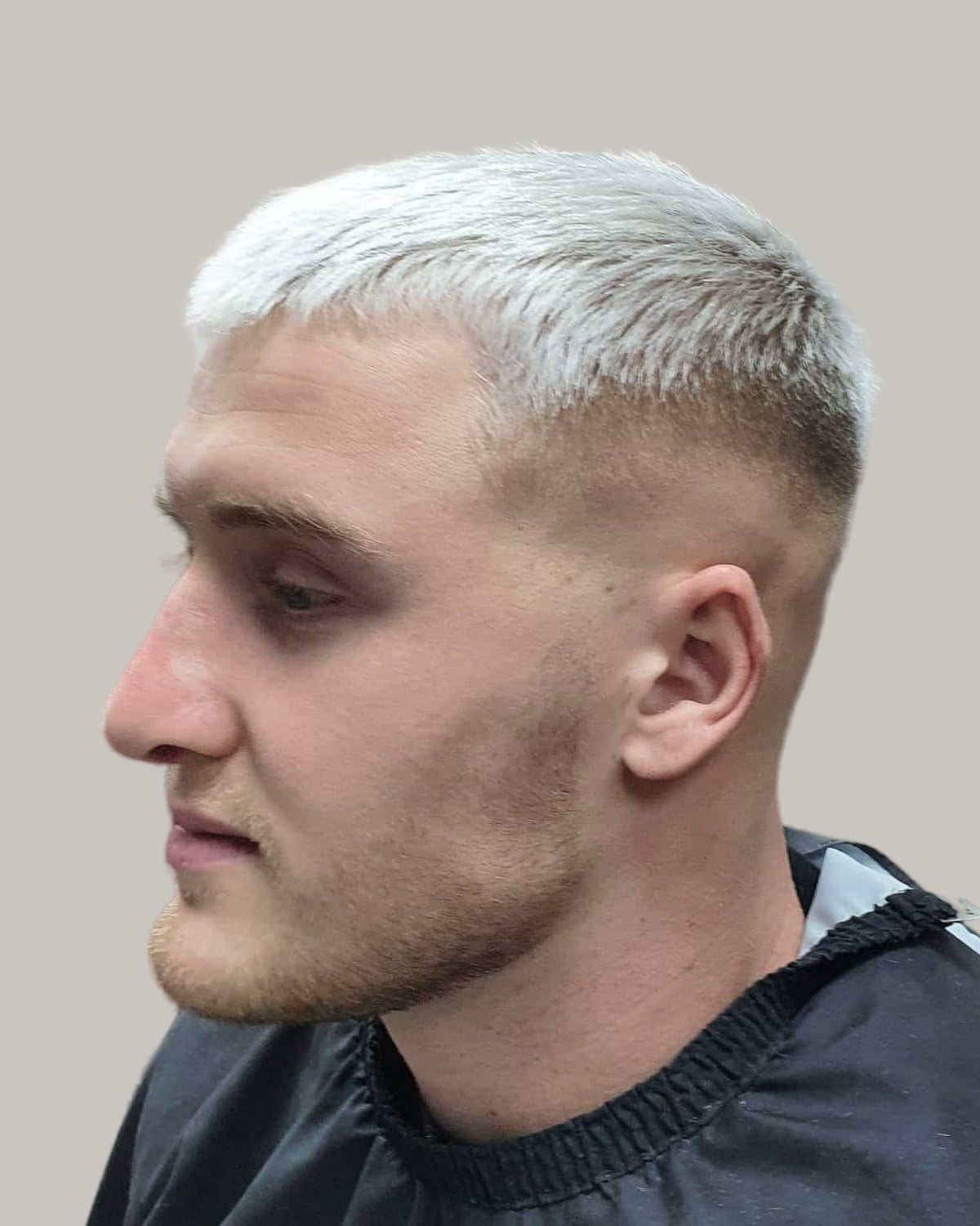 Man with a platinum crew cut, seen in profile