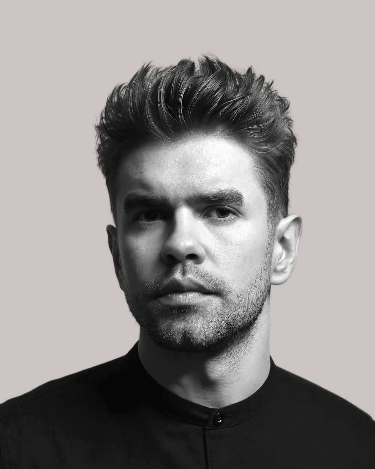 Man with a spiky crew cut, seen from the front in black and white