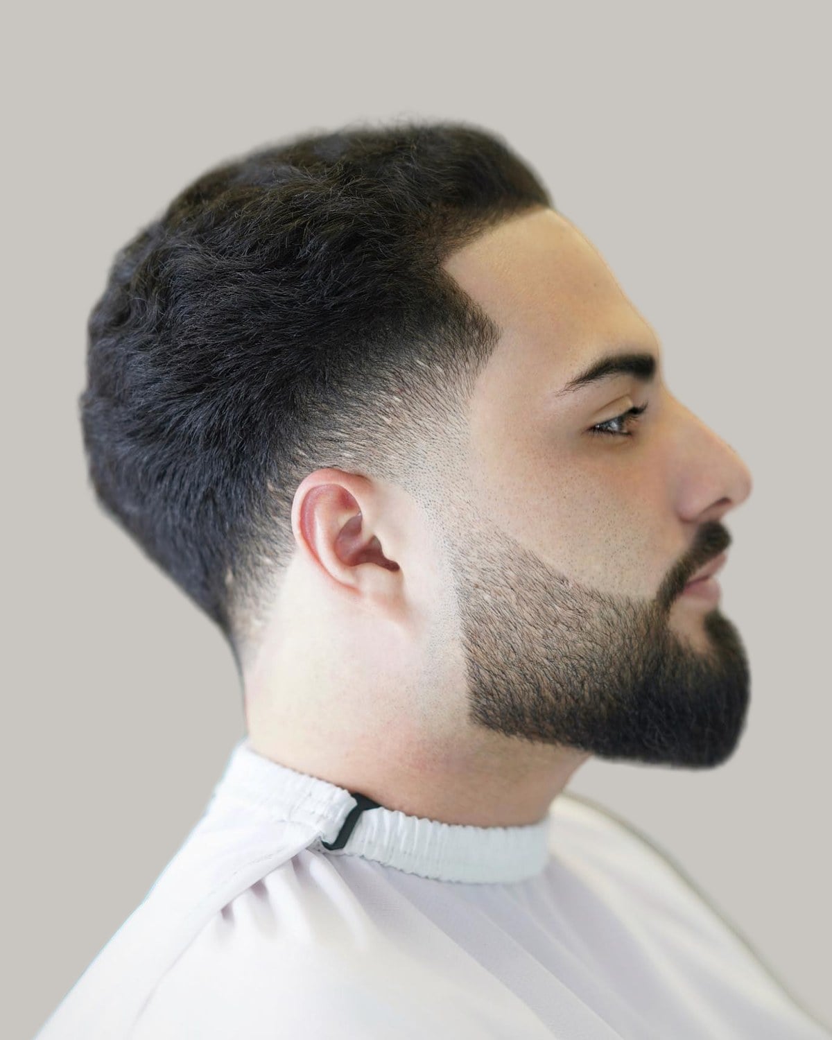Bearded man with a tapered crew cut, seen in profile