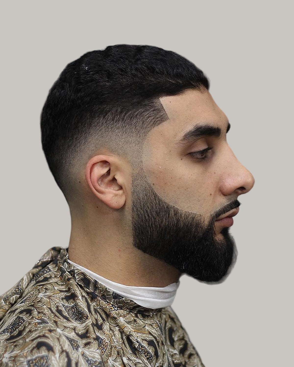 Man with a crew cut and a full beard, seen in profile