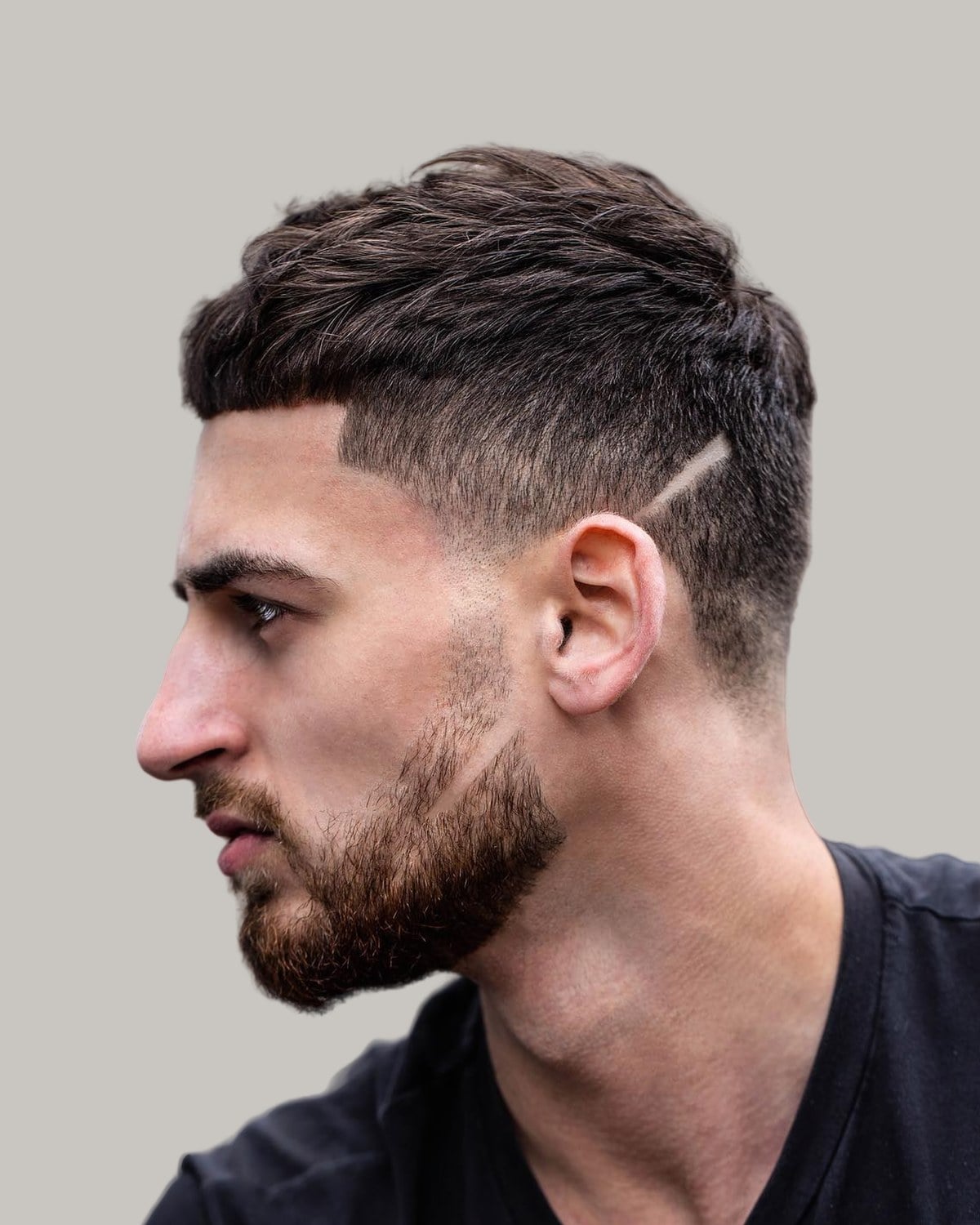 Man with a textured crew cut and a beard, seen in profile