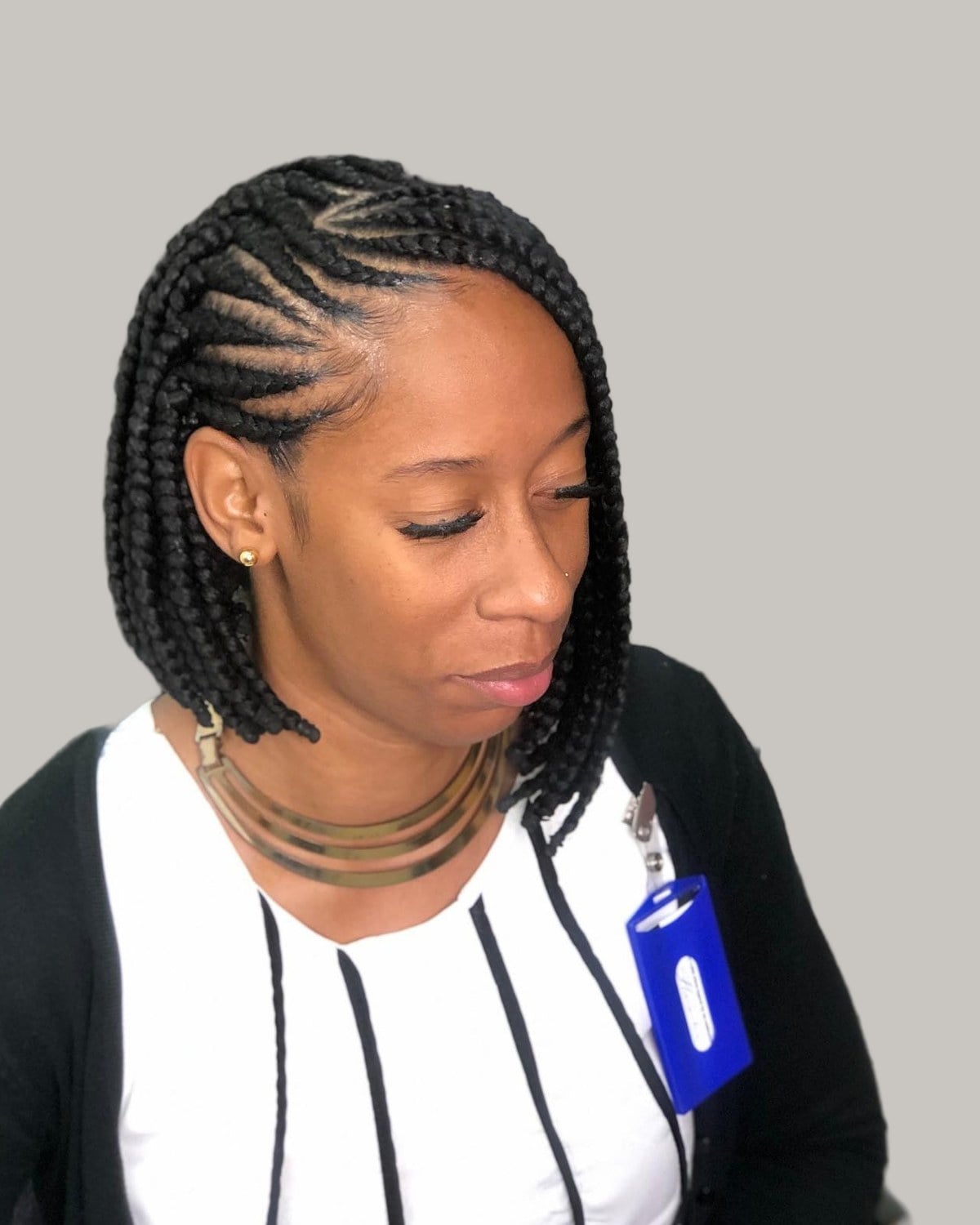 Woman in a black cardigan with an asymmetrical black Fulani braid bob