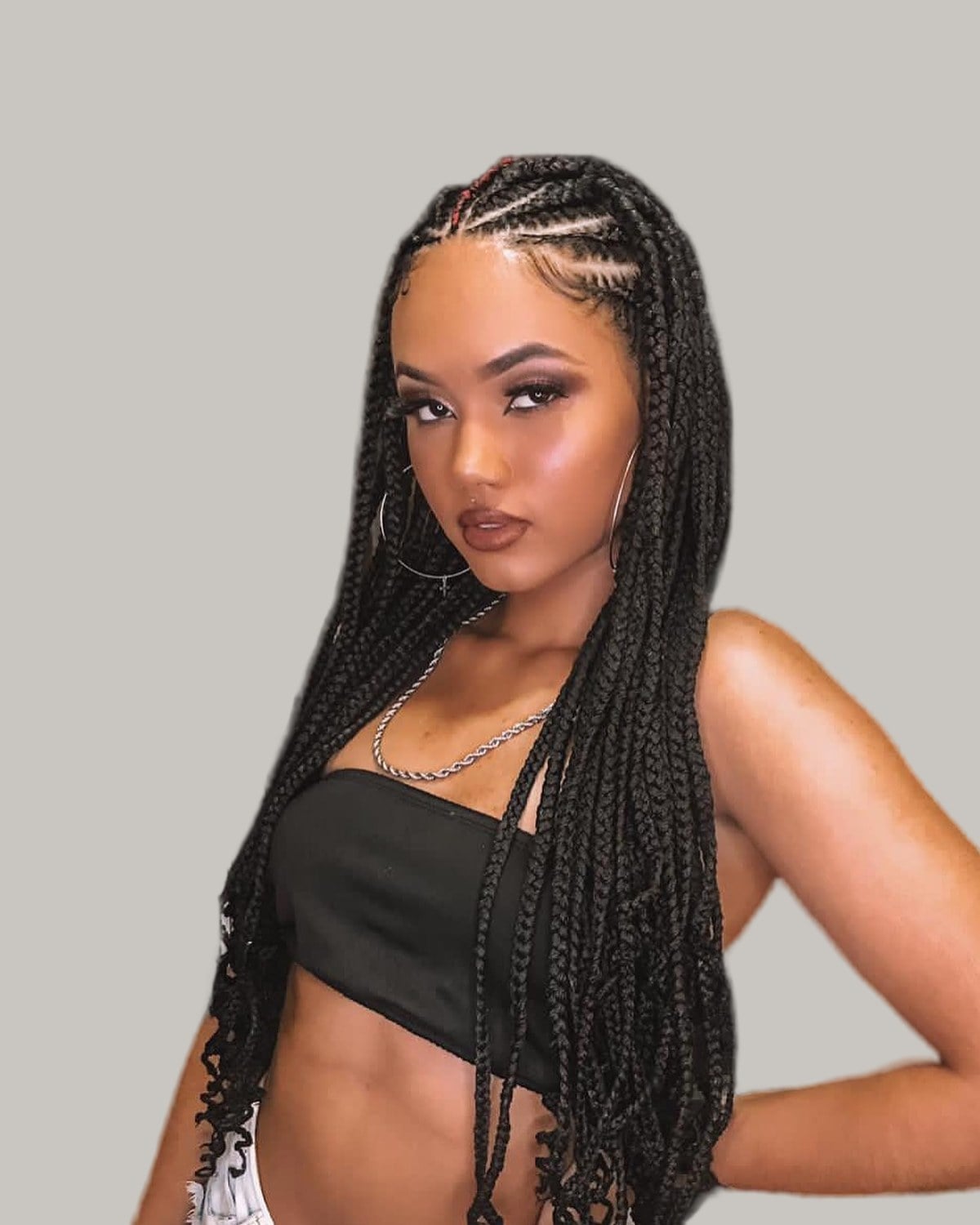 Woman with Fulani rows and long black braids with curly ends