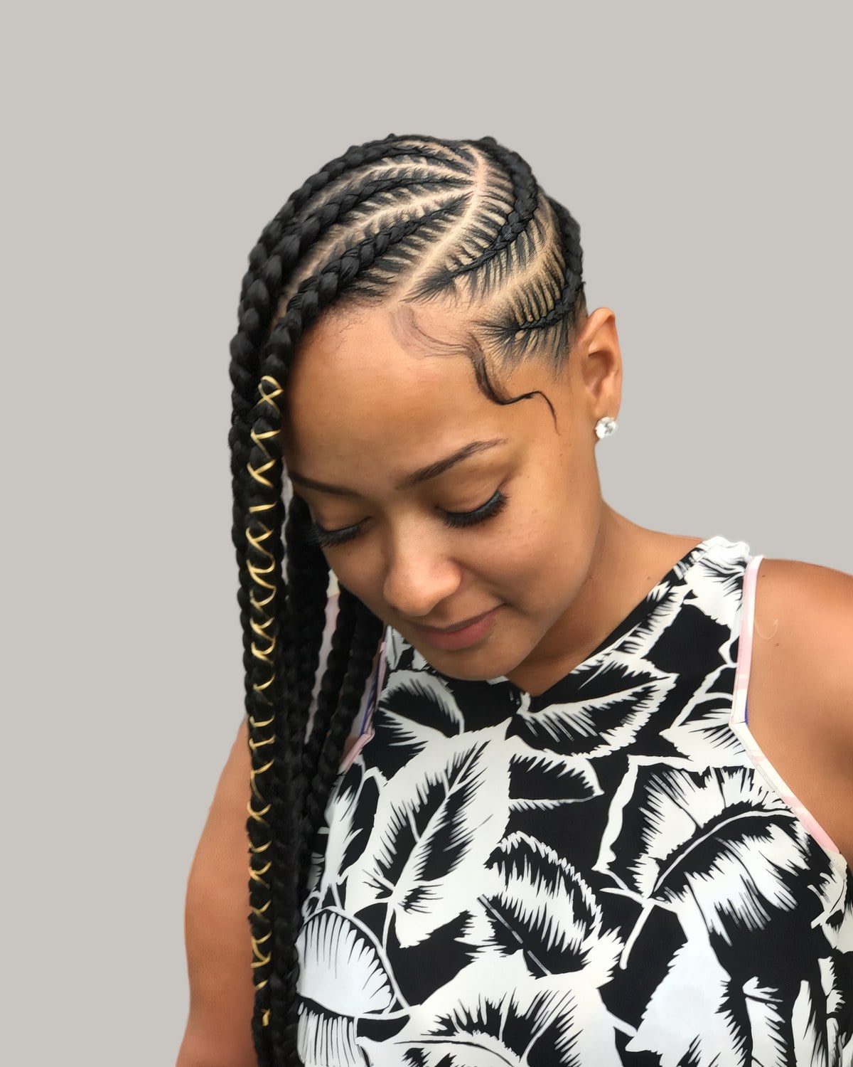 Woman looking down with side-swept lemonade Fulani braids and laid edges