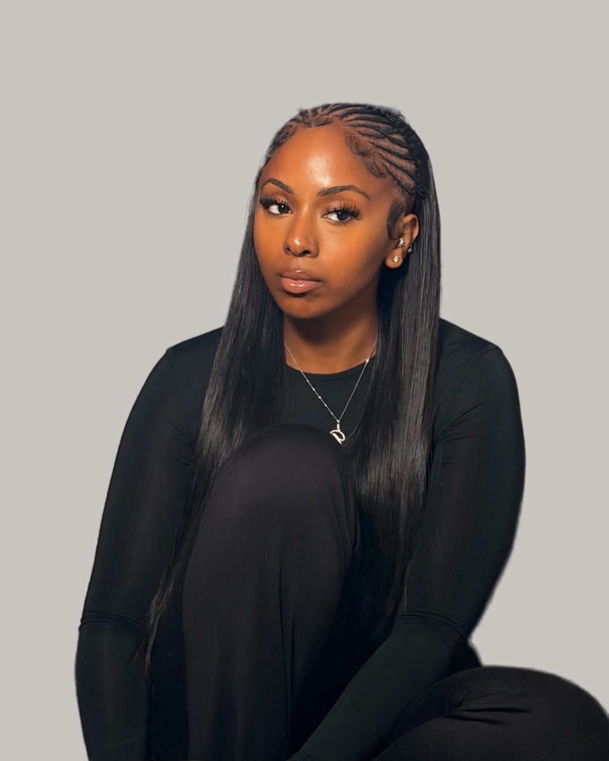 Woman in black with Fulani rows at the front and long straight sew-in hair