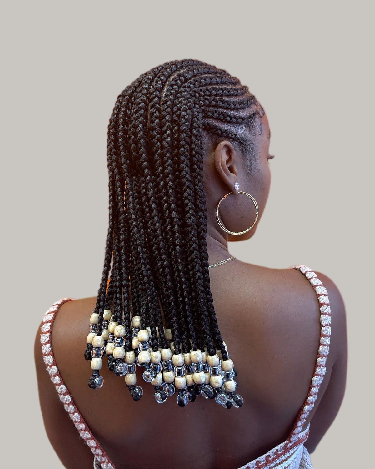 Back view of shoulder-length Fulani braids with cream and clear beads