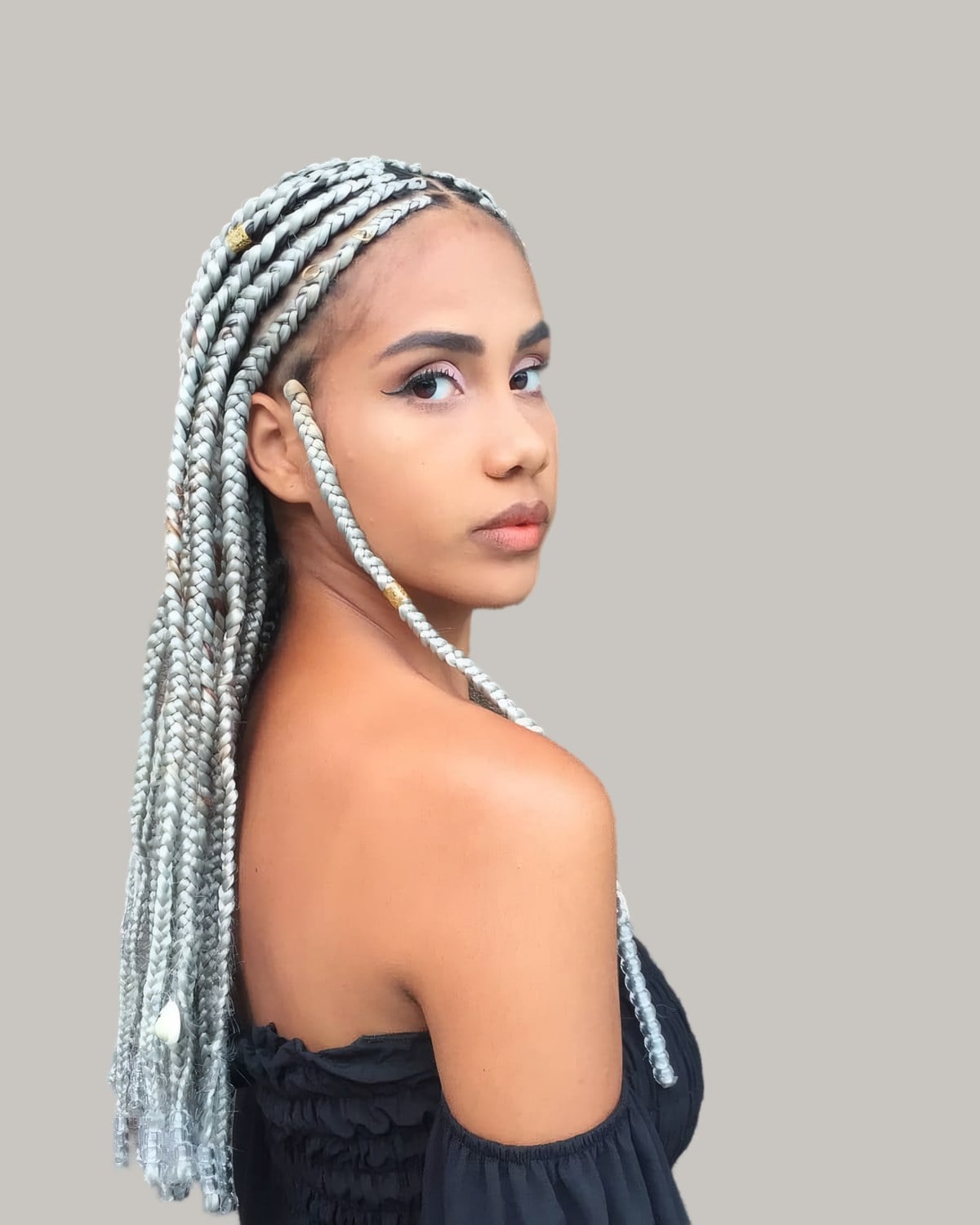 Woman in a black off-shoulder top in three-quarter view with long silver-gray Fulani braids