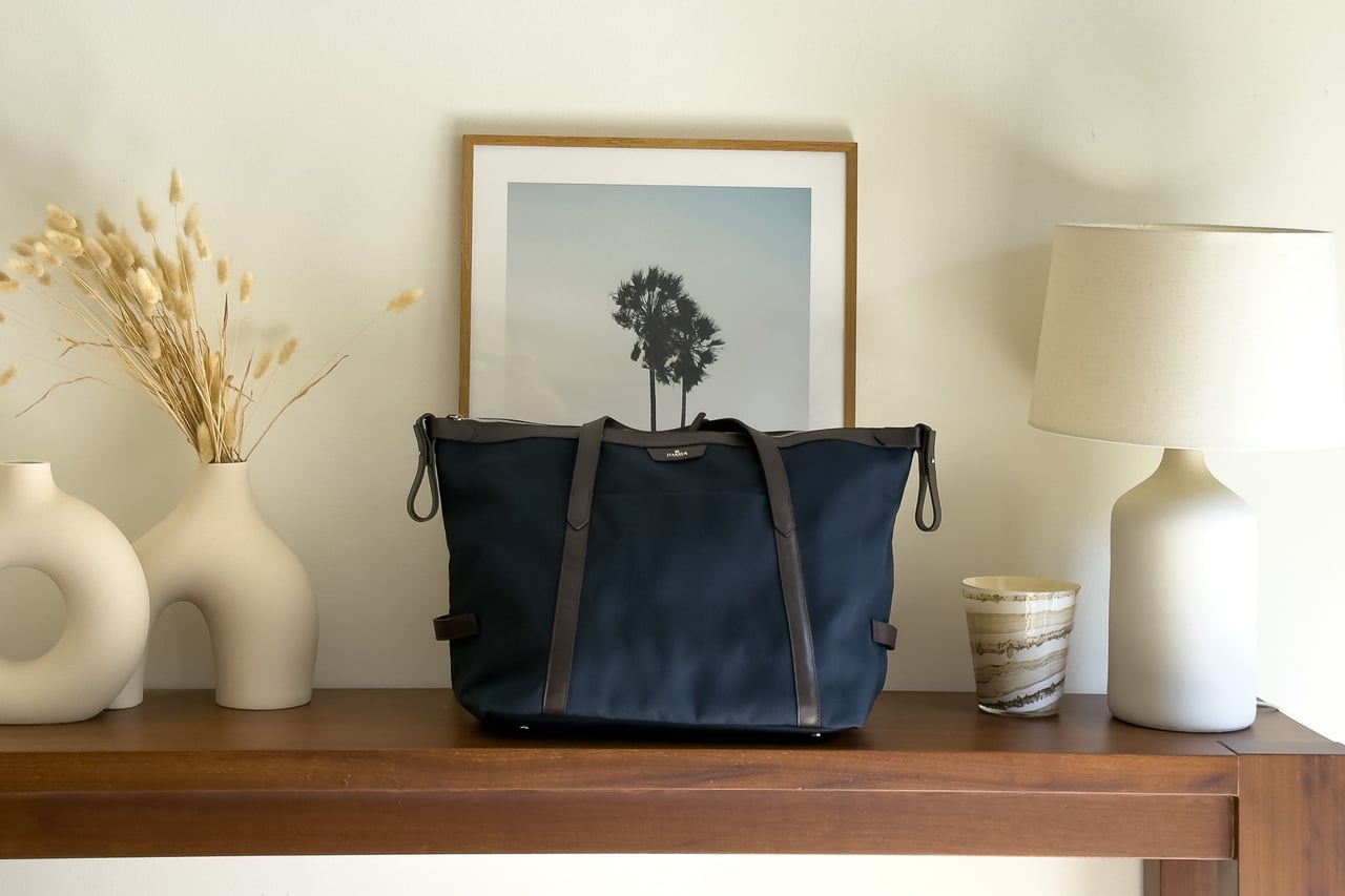 Harber London recycled-fabric Overnight Bag in Navy Blue with leather trims on a wooden console - Luxe Digital