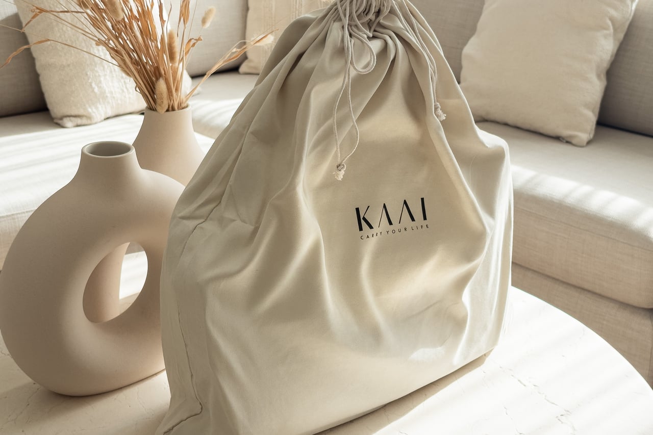KAAI Voyager branded cream dust bag on a living room table - Luxe Digital