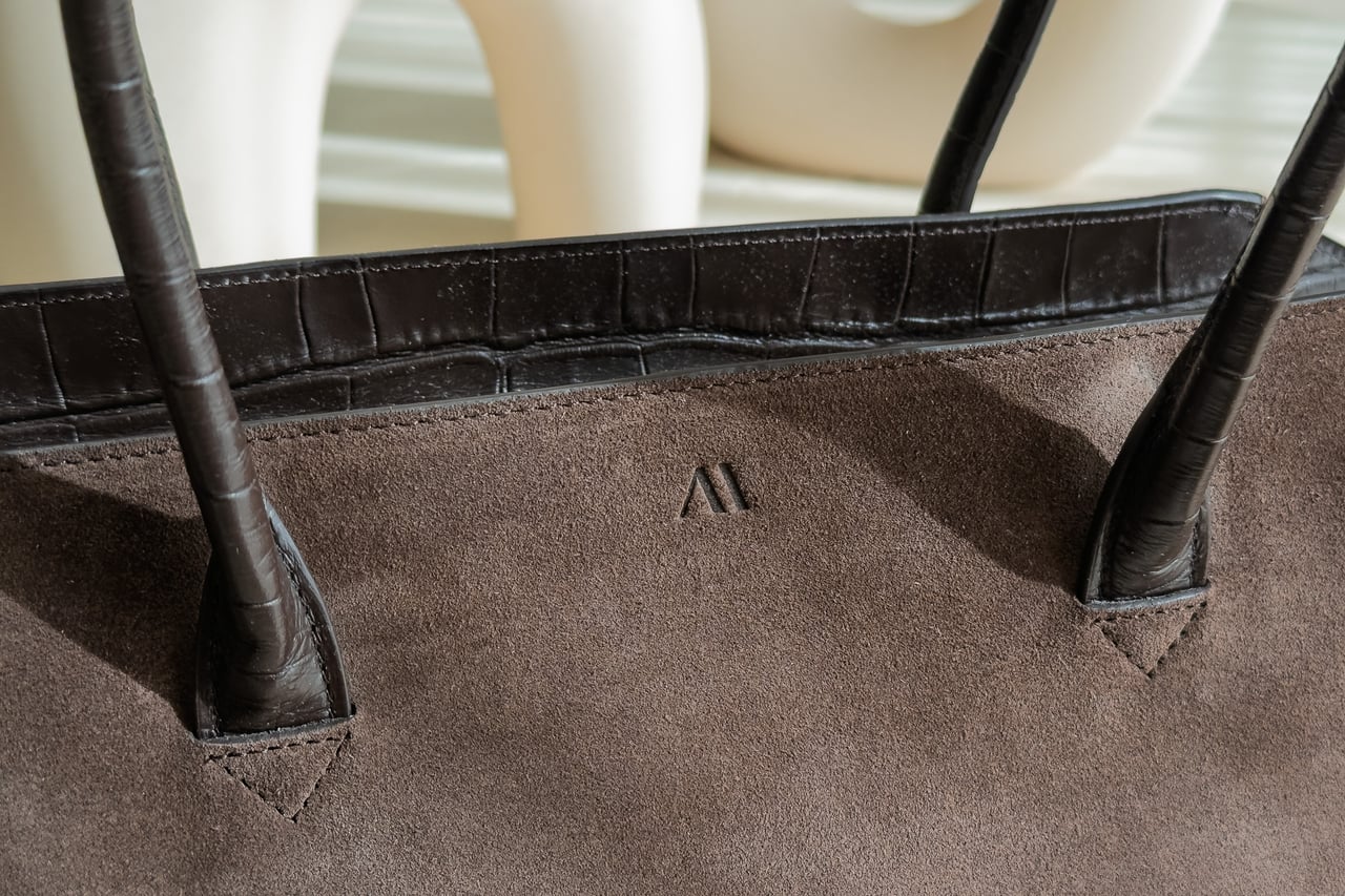 Close-up of the KAAI Voyager Italian suede with its embossed logo - Luxe Digital