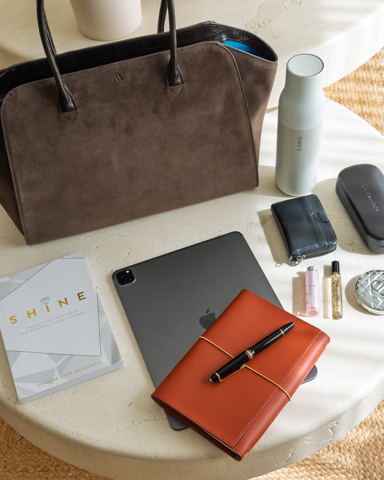 KAAI Voyager beside a tablet, notebook, wallet and water bottle - Luxe Digital