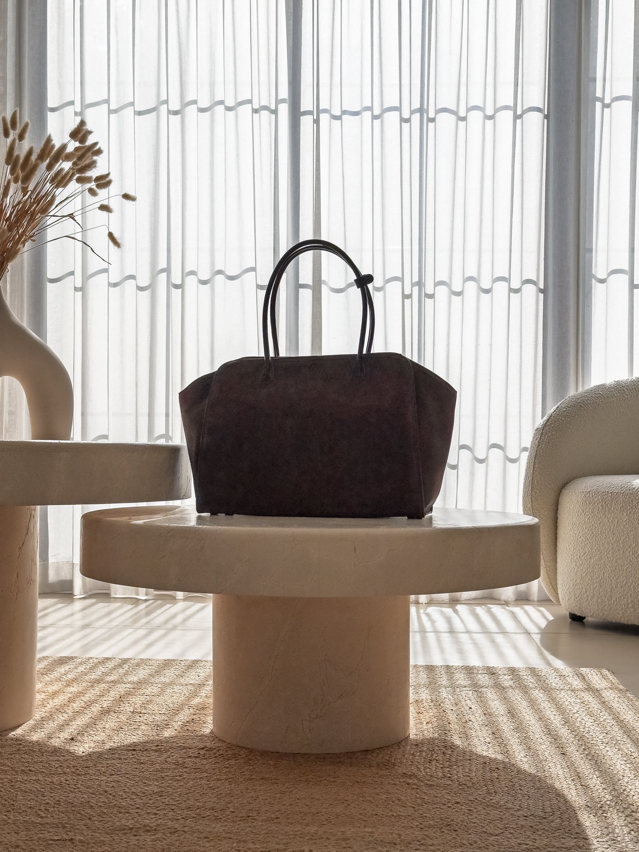KAAI Voyager structured tote standing on a round side table - Luxe Digital