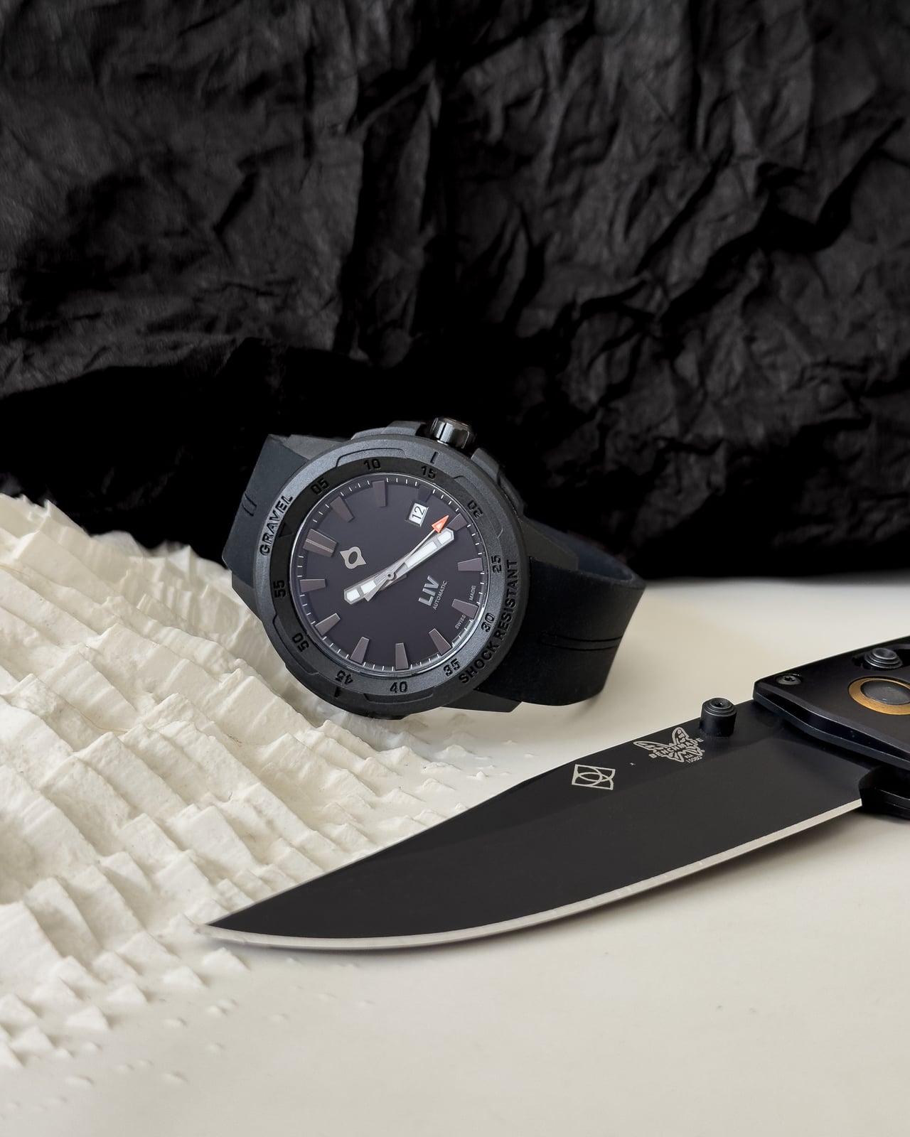 LIV Gravel Stealth Auto tool watch next to a black folding knife - Luxe Digital