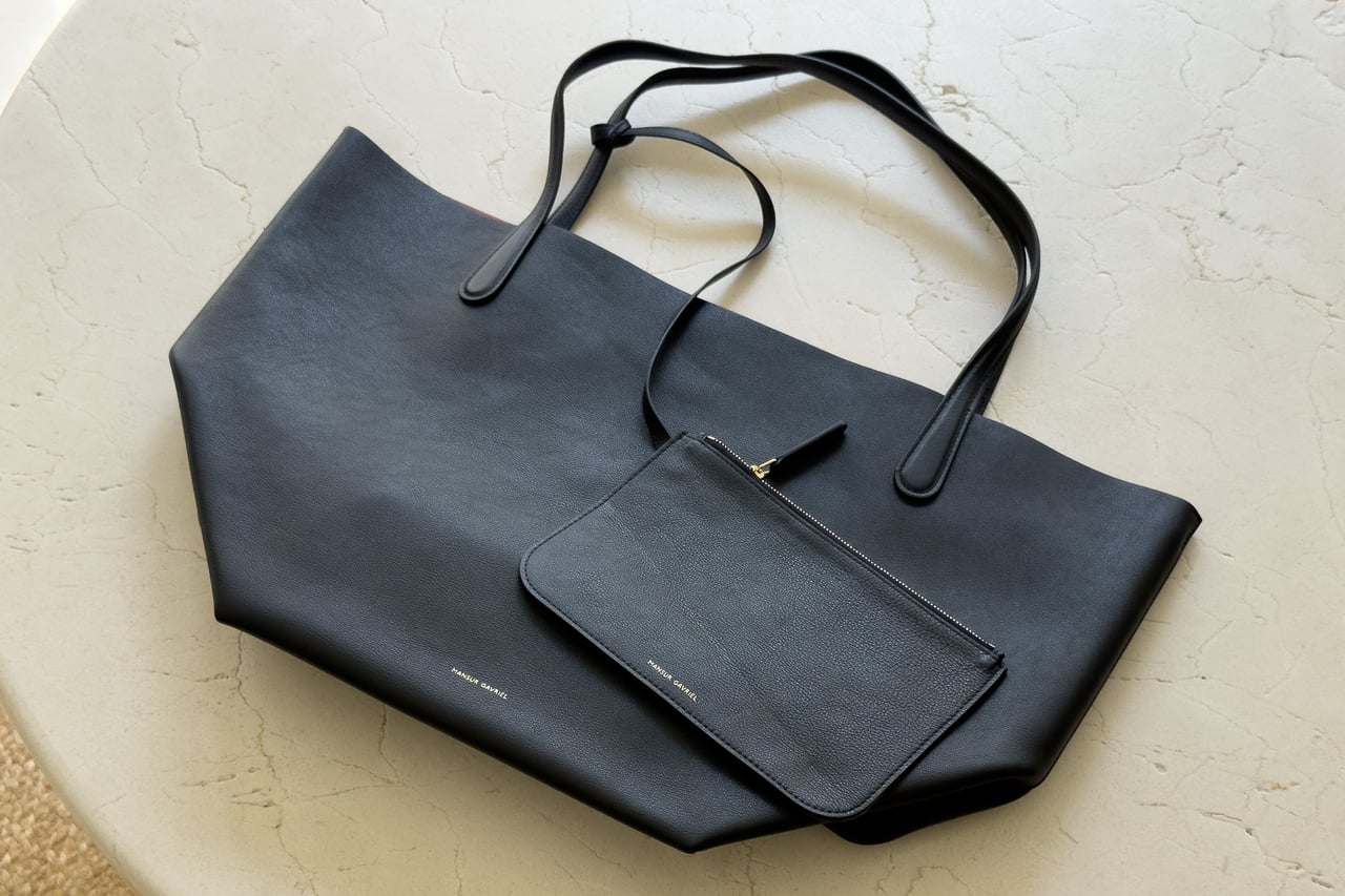 Mansur Gavriel Everyday Soft Tote lying flat on a stone table with its small leather pouch - Luxe Digital