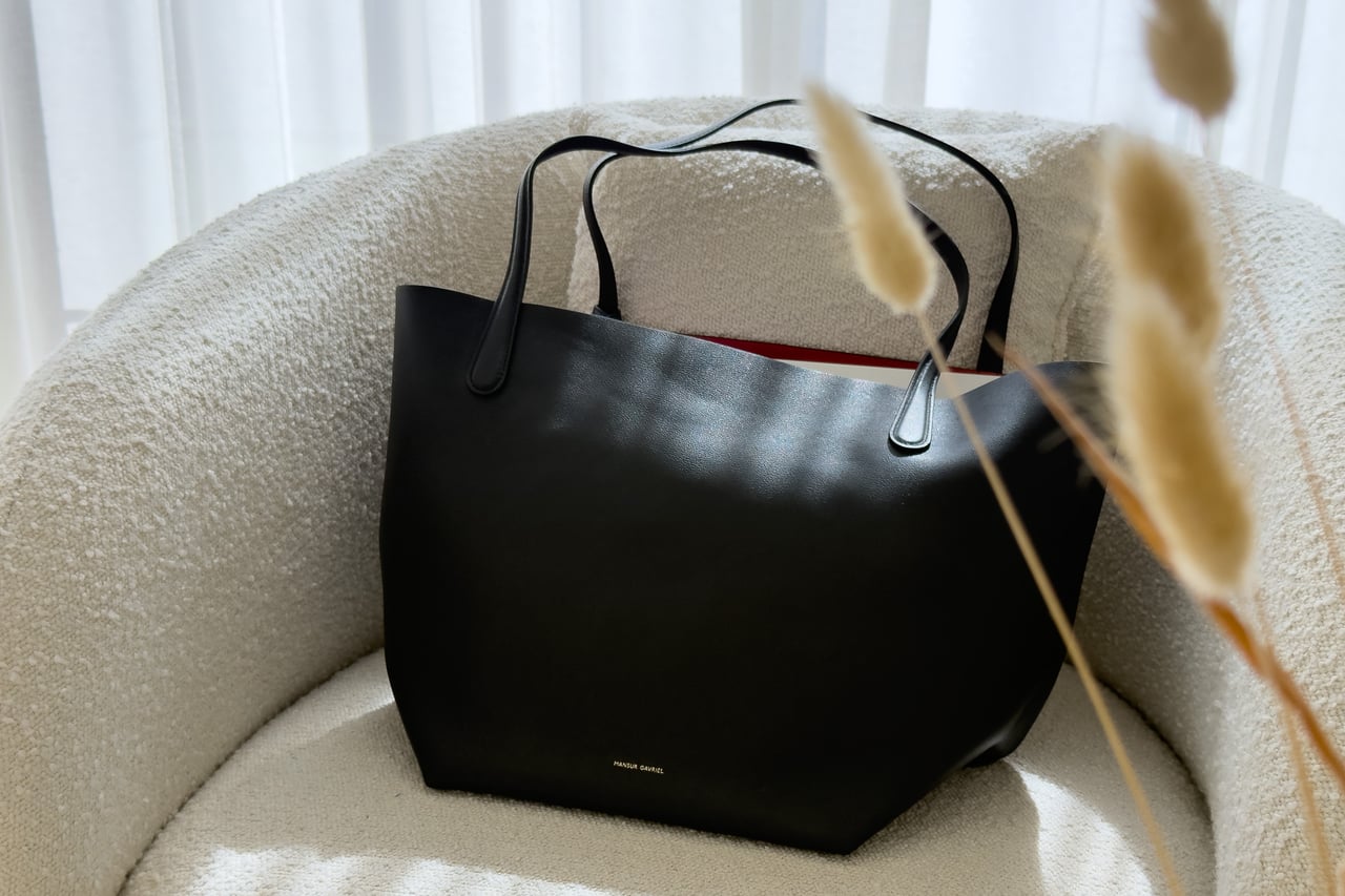 Mansur Gavriel Everyday Soft Tote in Black/Flamma on a cream armchair - Luxe Digital